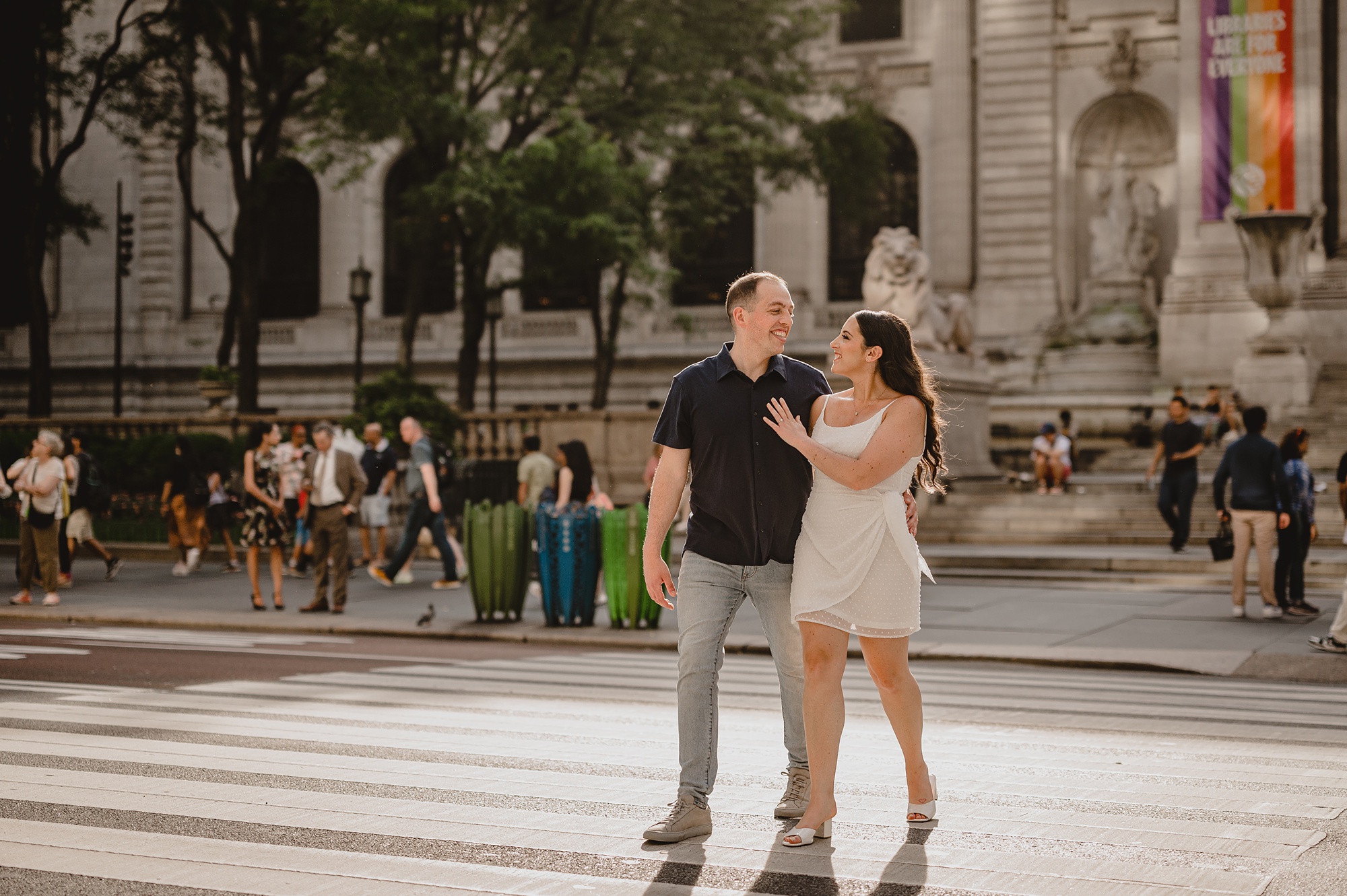 couple walks in front of the New York Public Library