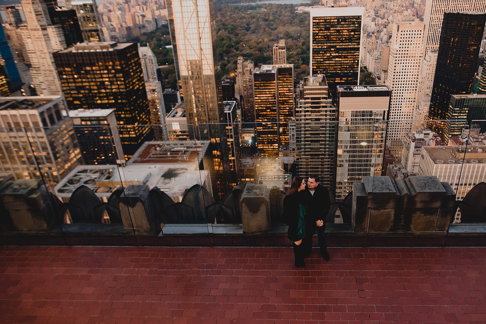 view of couple in front of NYC skyline at Top of the Rock