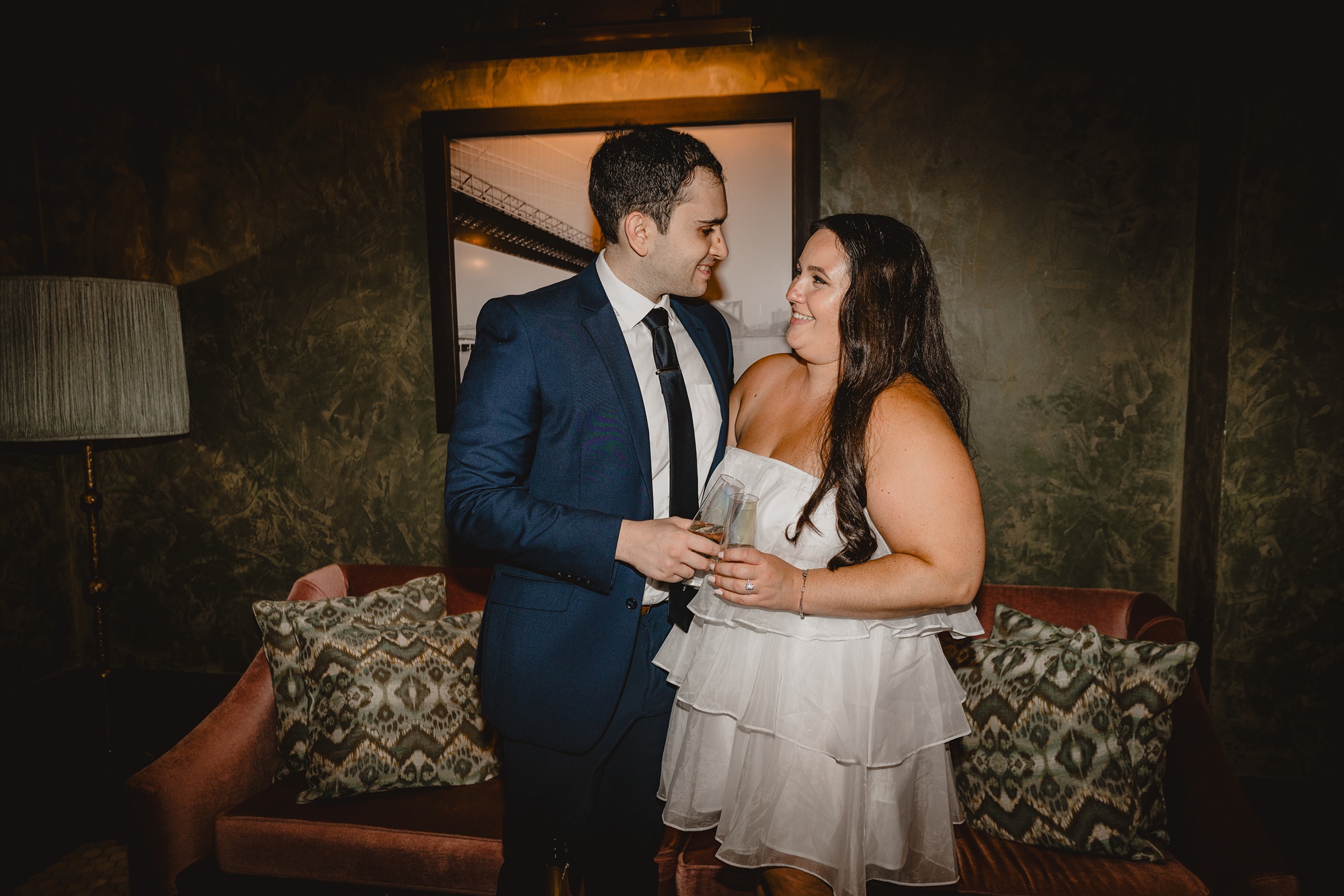 man smiles at woman in short white dress