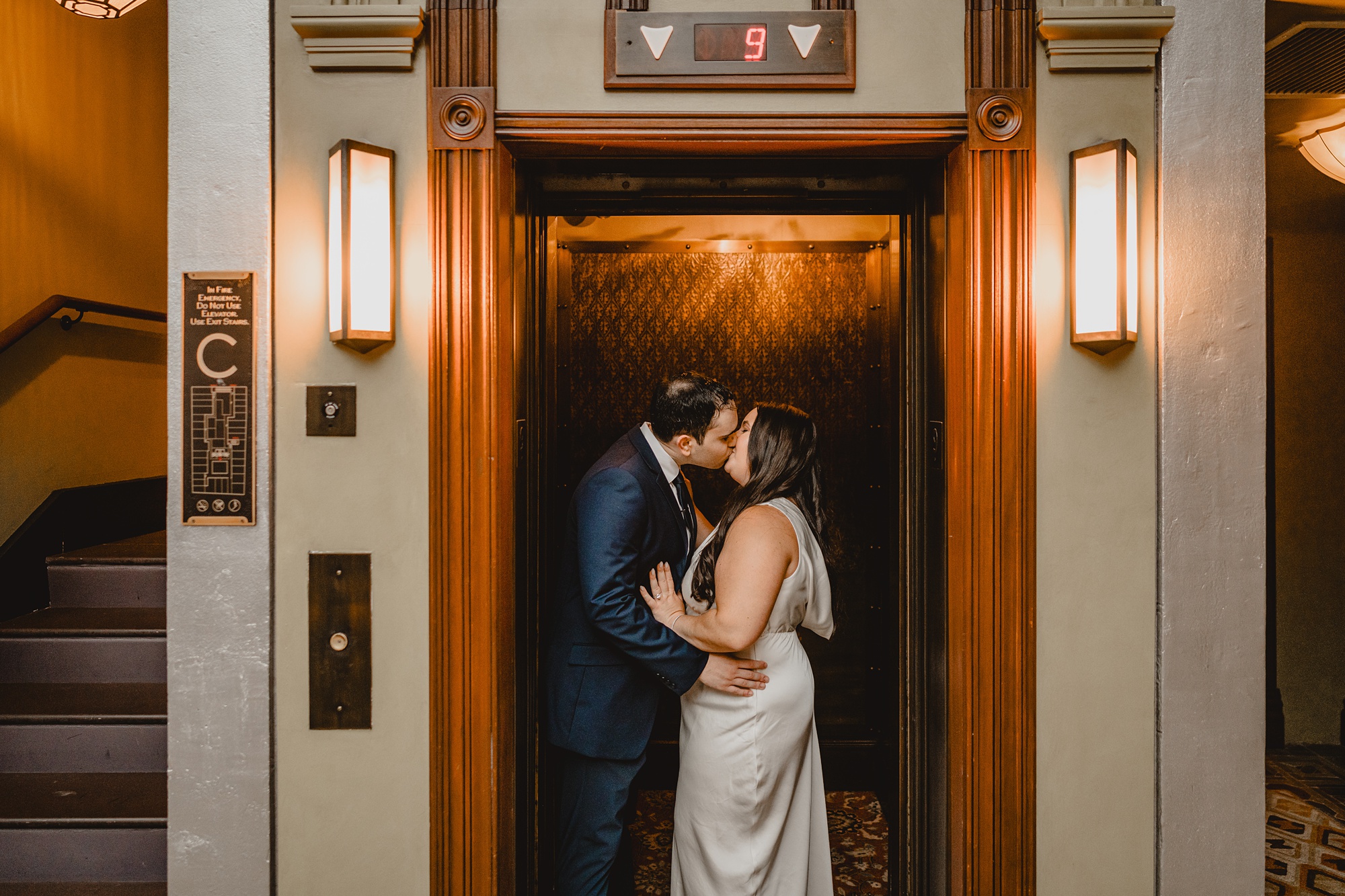 engaged couple kisses inside elevator of the Beekman Hotel
