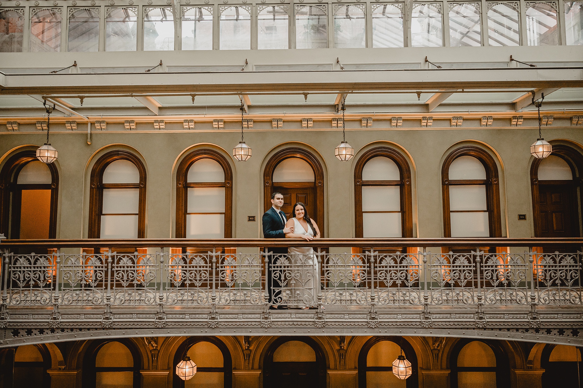 man and woman hug on balcony inside the Beekman Hotel