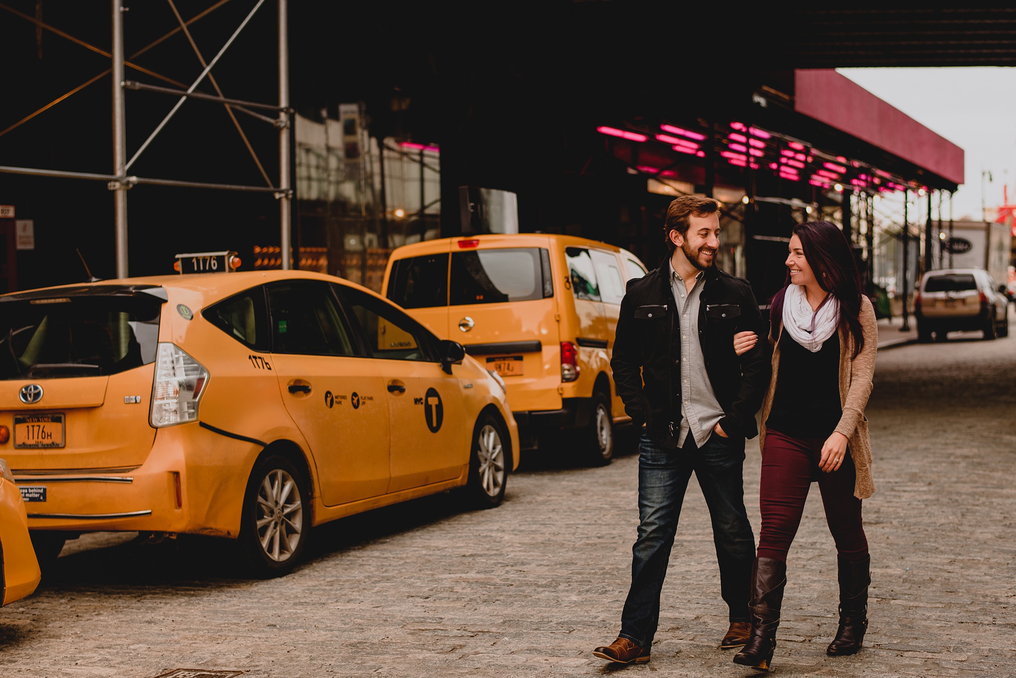 man and woman walk near NYC yellow taxis 