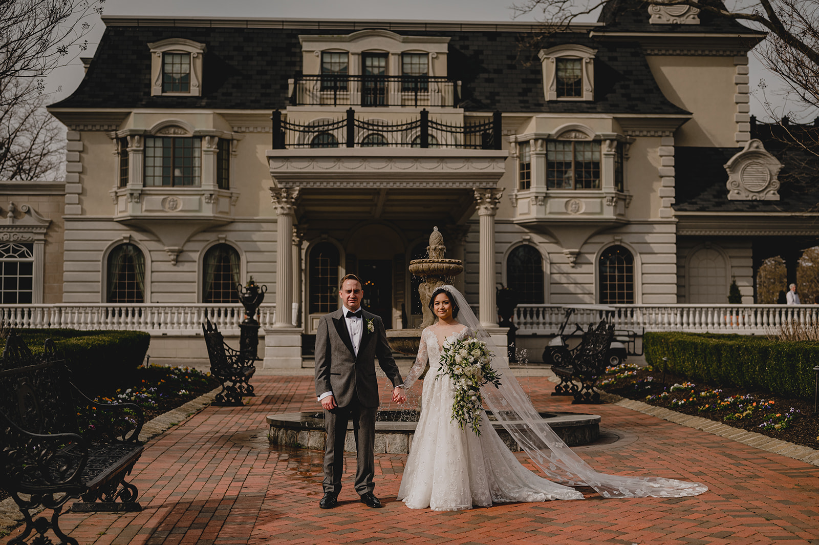 newlyweds hold hands standing outside Ashford Estate