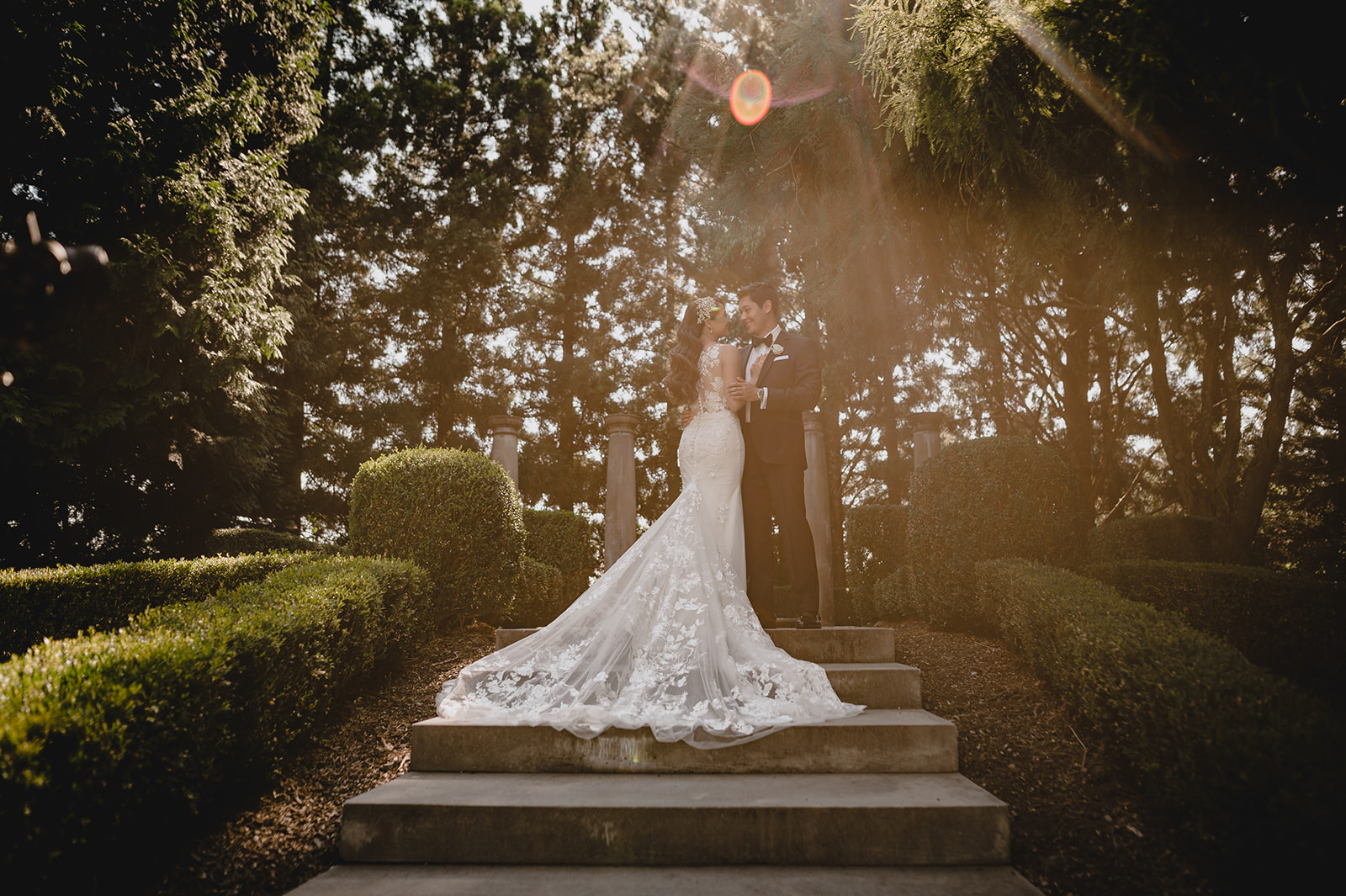 bride and groom kiss on staircase in gardens of Ashford Estate