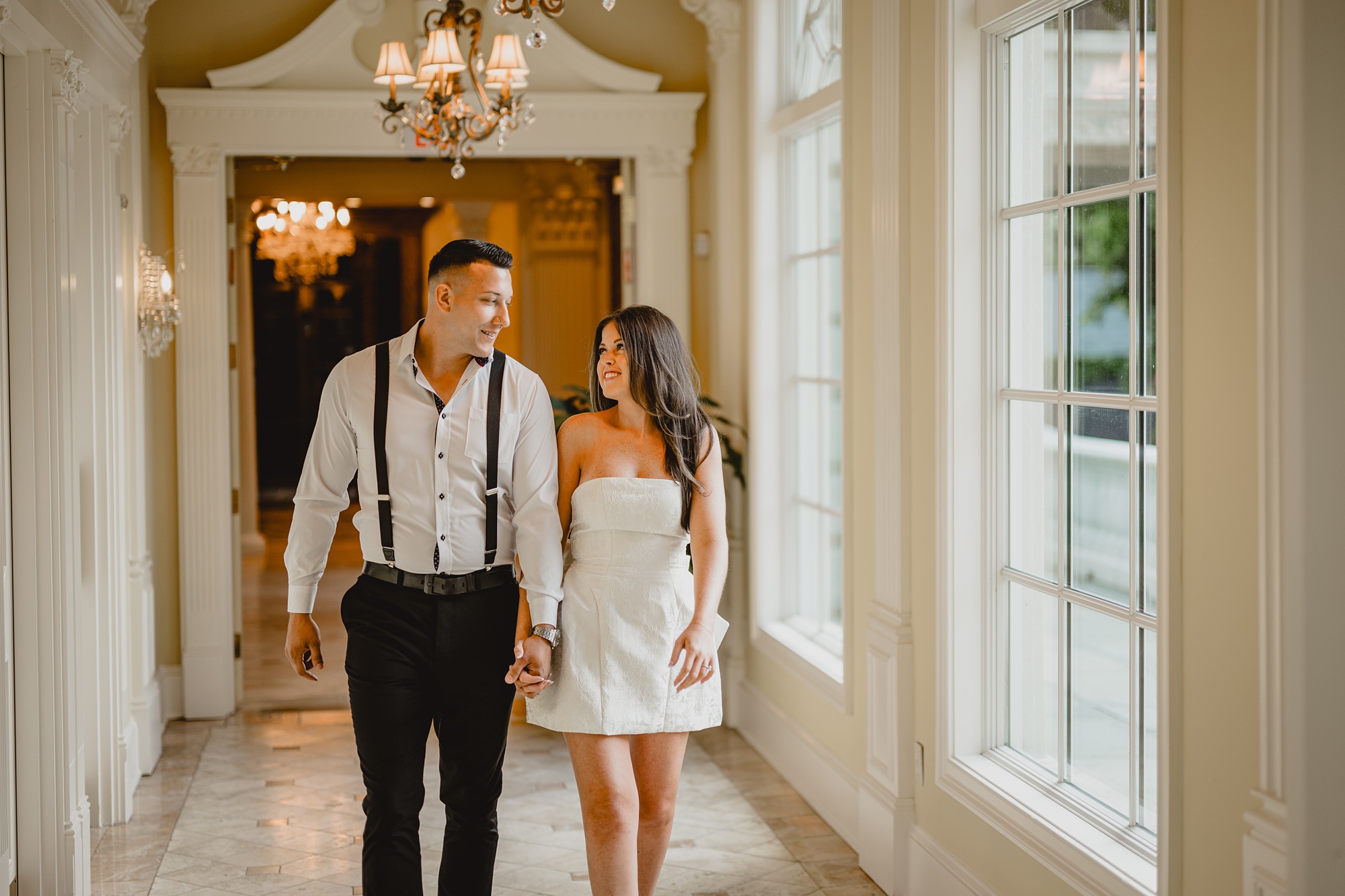 engaged couple holds hands walking through the Ashford Estate