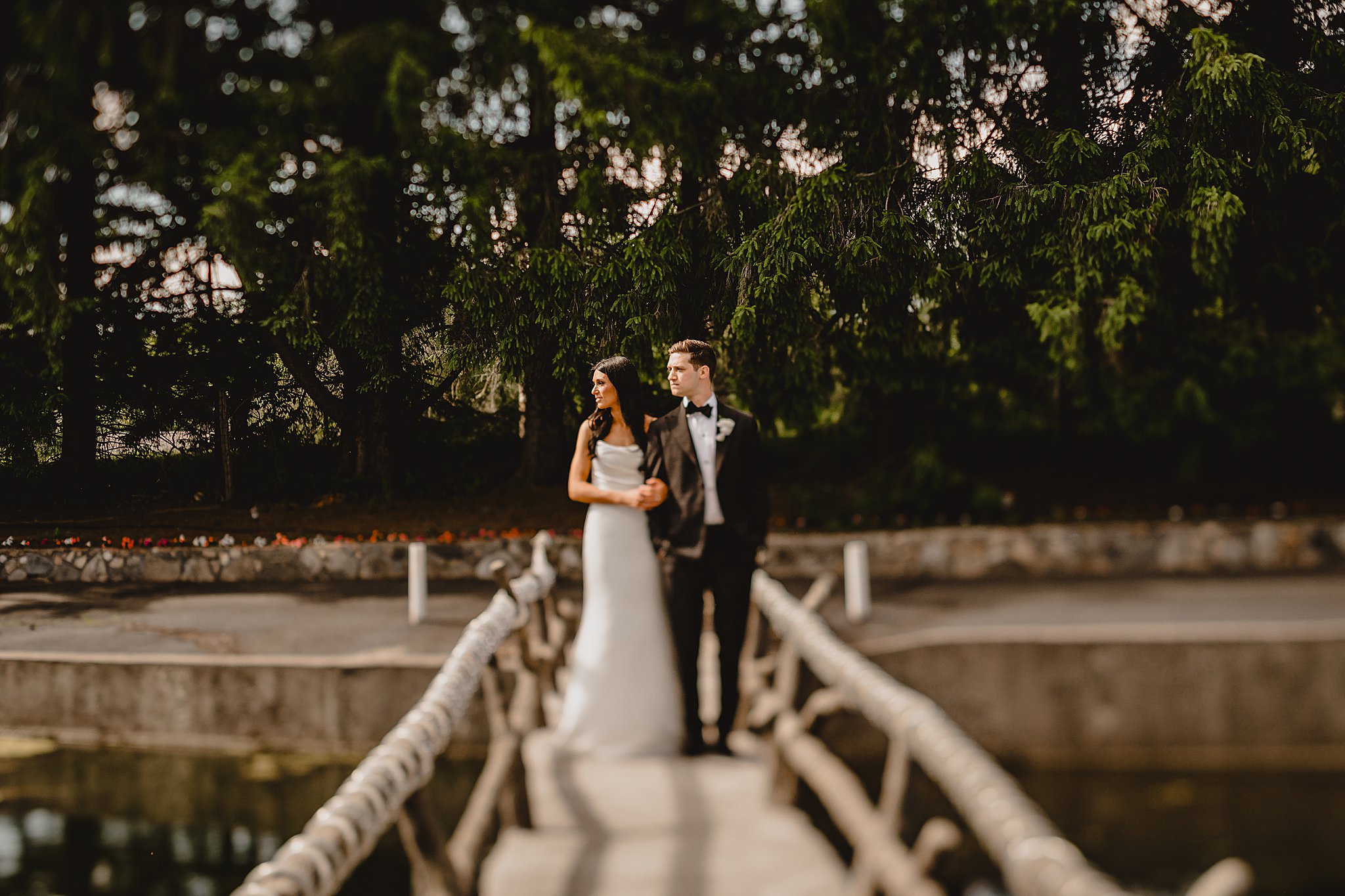 couple stands on wooden bridge at the Reserve at Perona Farms
