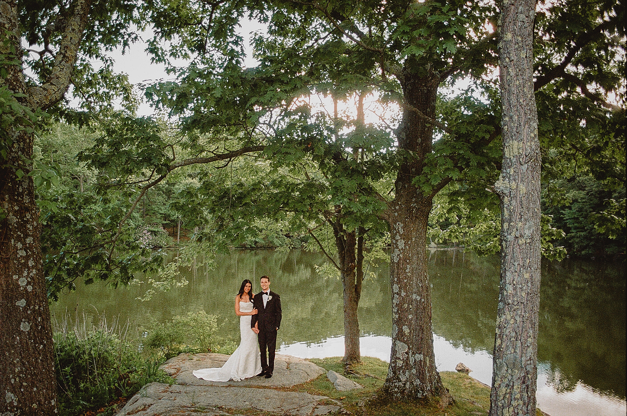 couple hugs near pond at the Reserve at Perona Farms