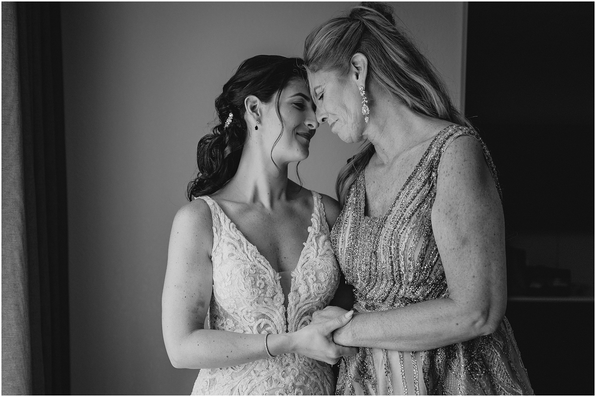 bride and mom hug leaning heads together at the Conservatory in New Jersey