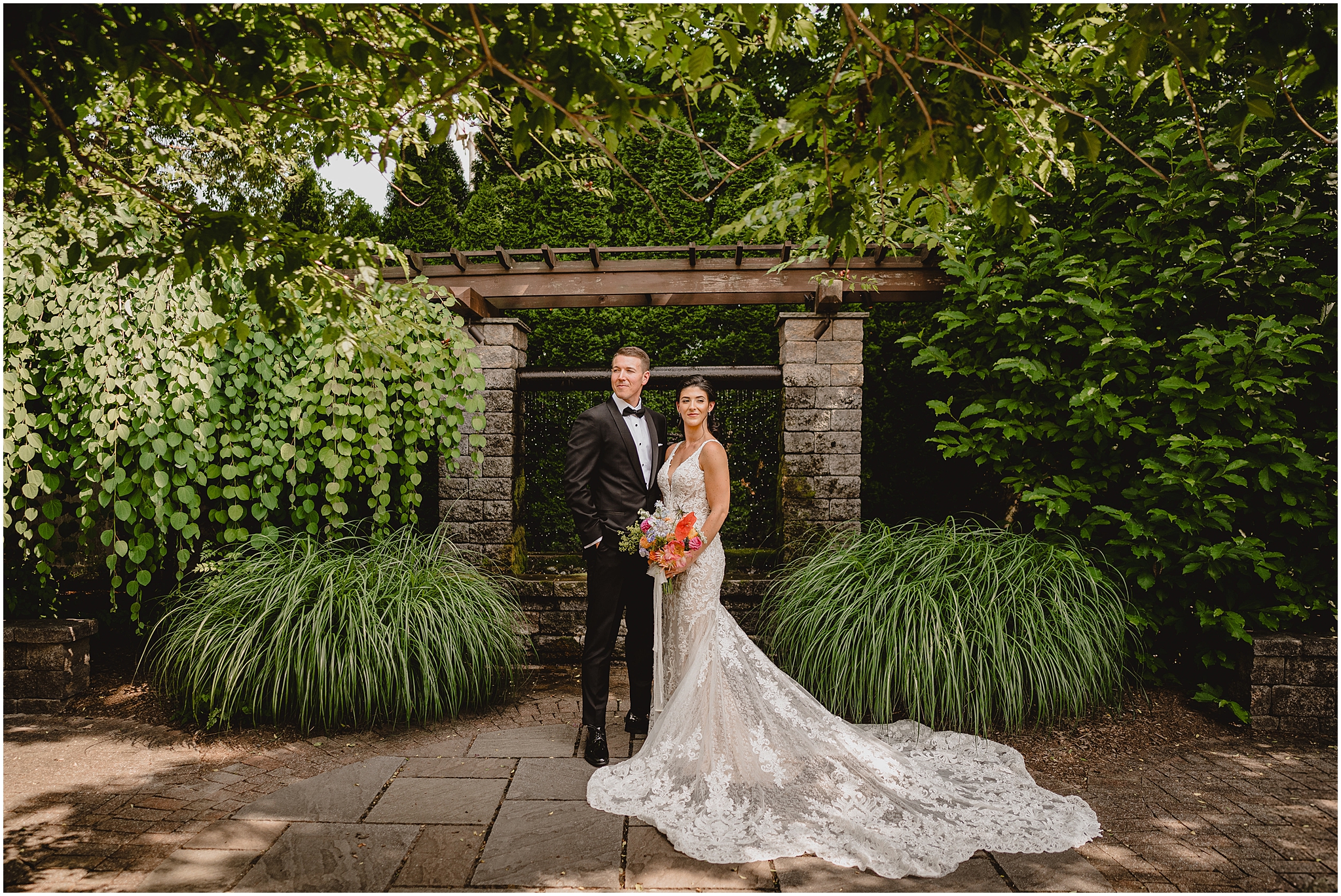 bride and groom hug in front of stone arbor at the Conservatory at Sussex County Fairgrounds