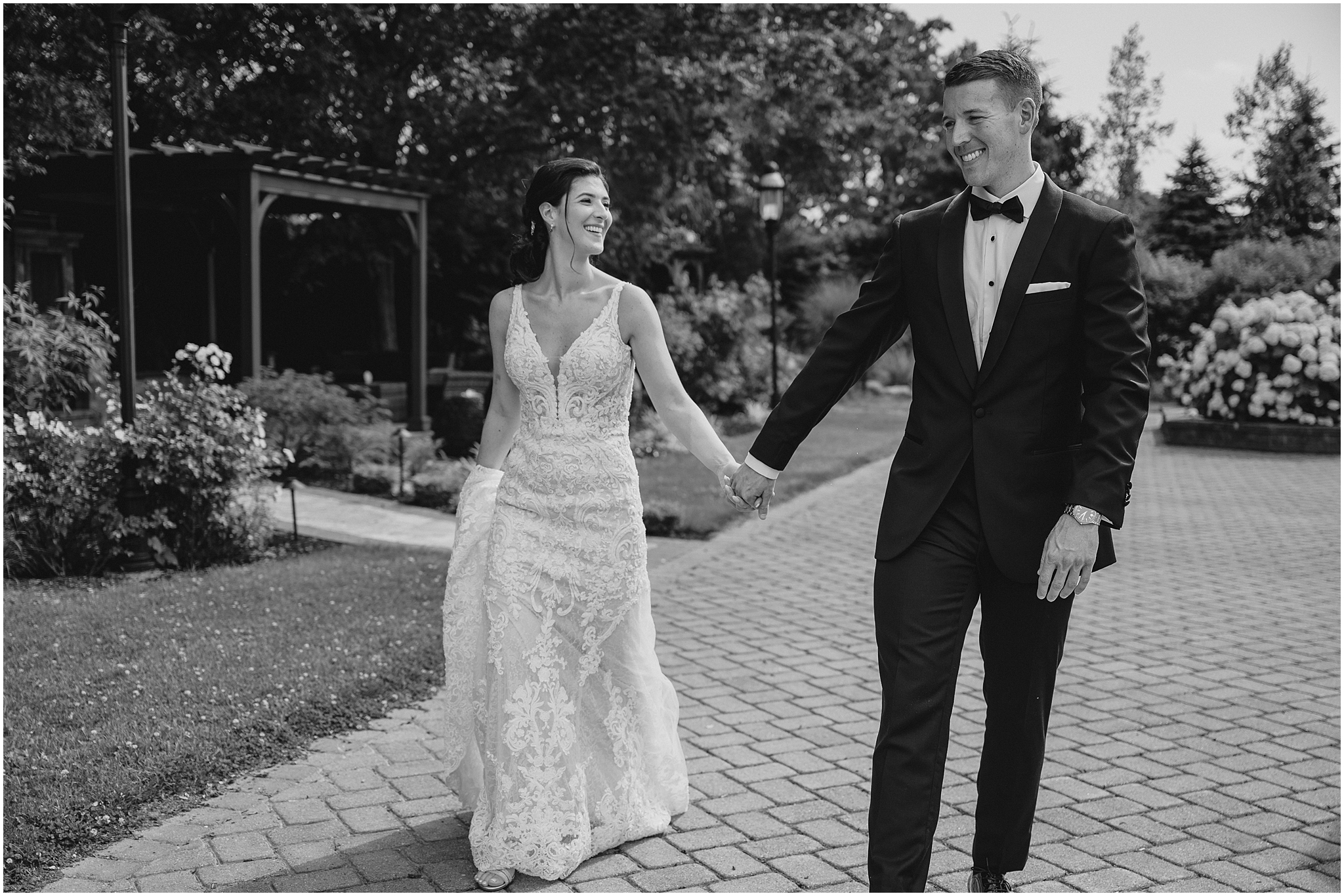 bride and groom hold hands walking on brick pathway outside the Conservatory at Sussex County Fairgrounds