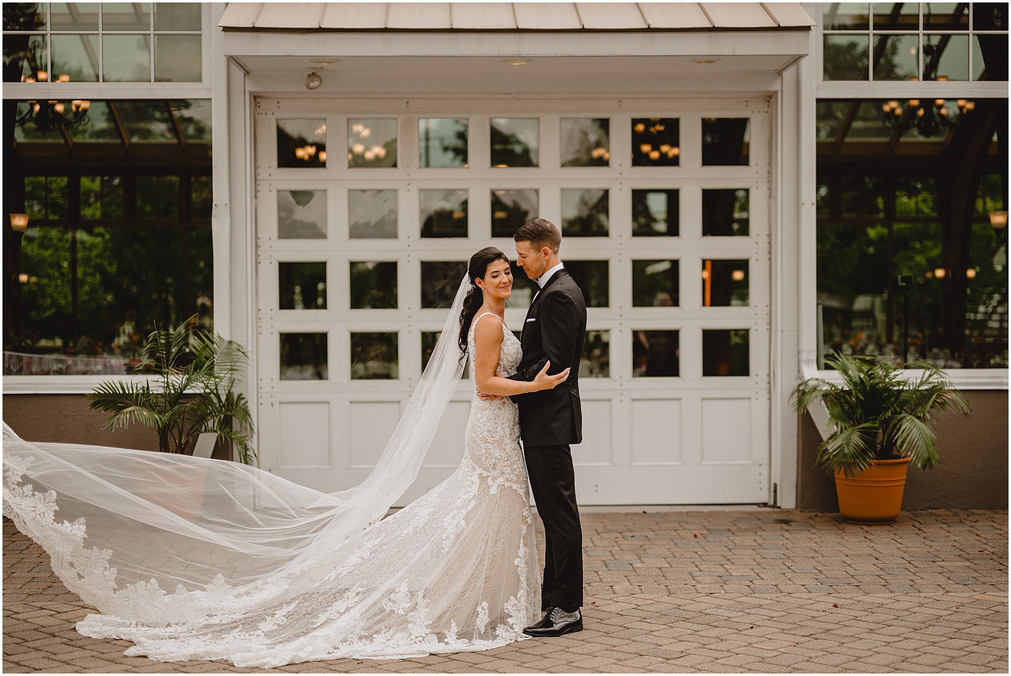 bride and groom hug in front of white door and window outside the Conservatory at Sussex County Fairgrounds