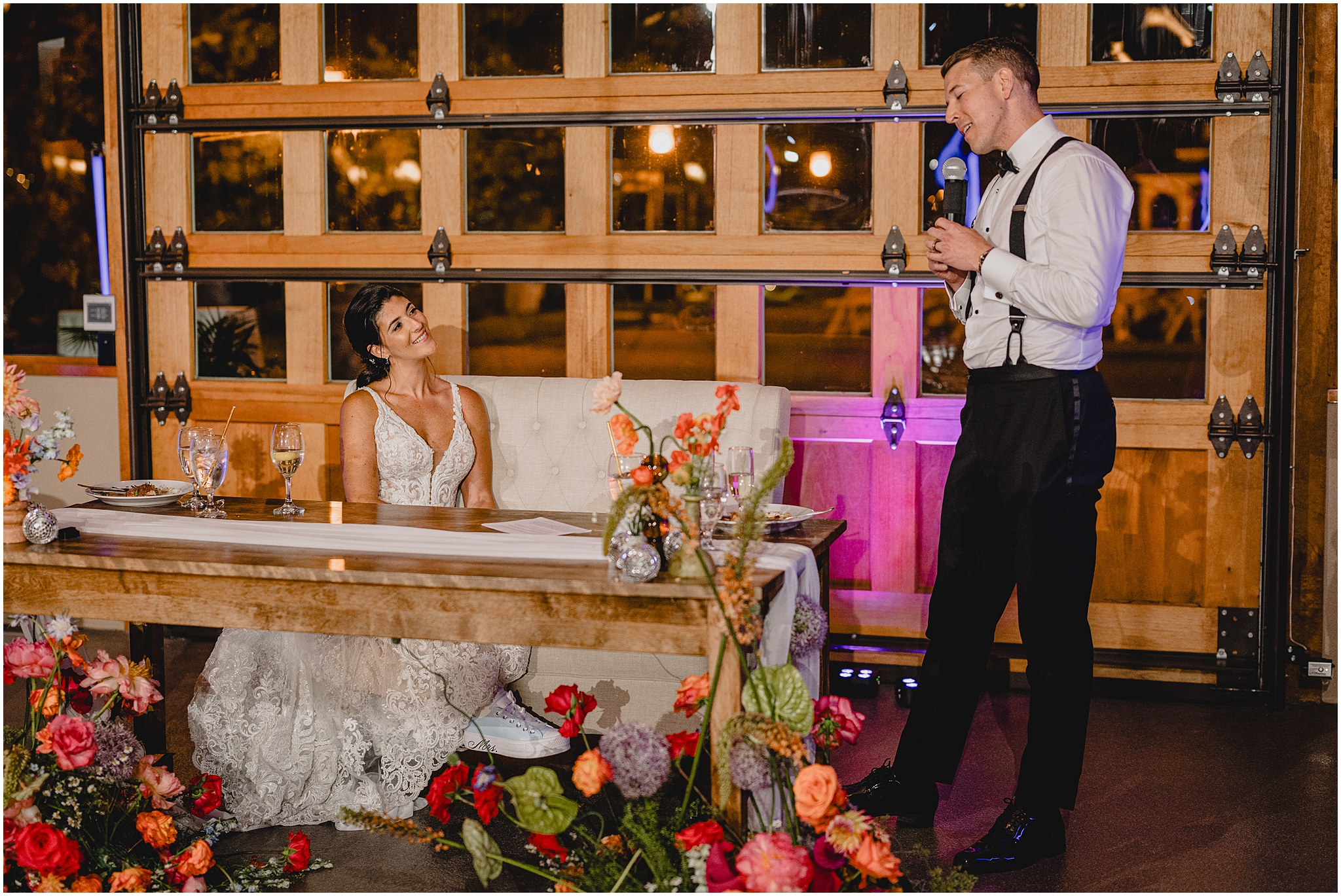 groom sings to bride during toast while she sits at sweetheart table at the Conservatory 