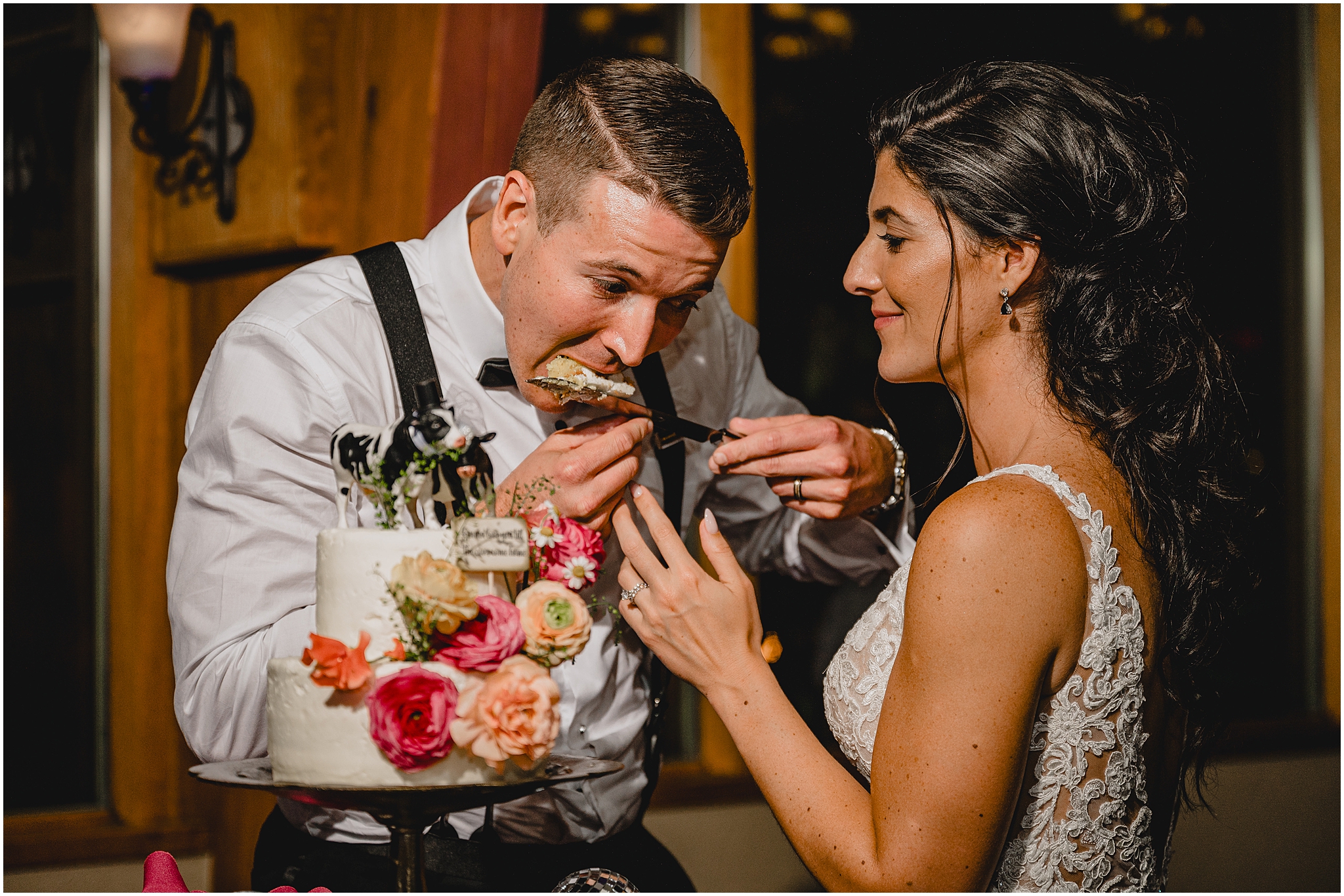 groom eats slice of cake off knife during wedding reception at Conservatory at Sussex County Fairgrounds