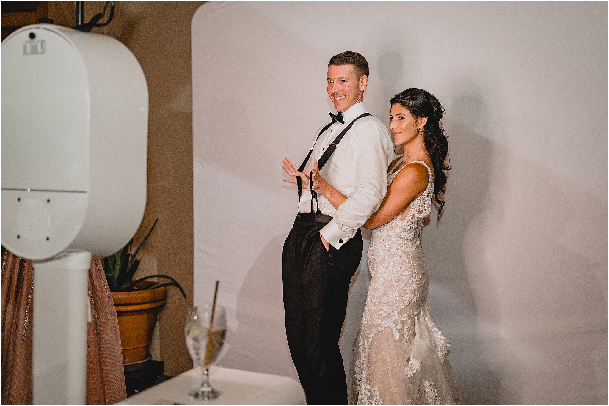 bride hugs groom from behind during photo booth during NJ wedding reception 