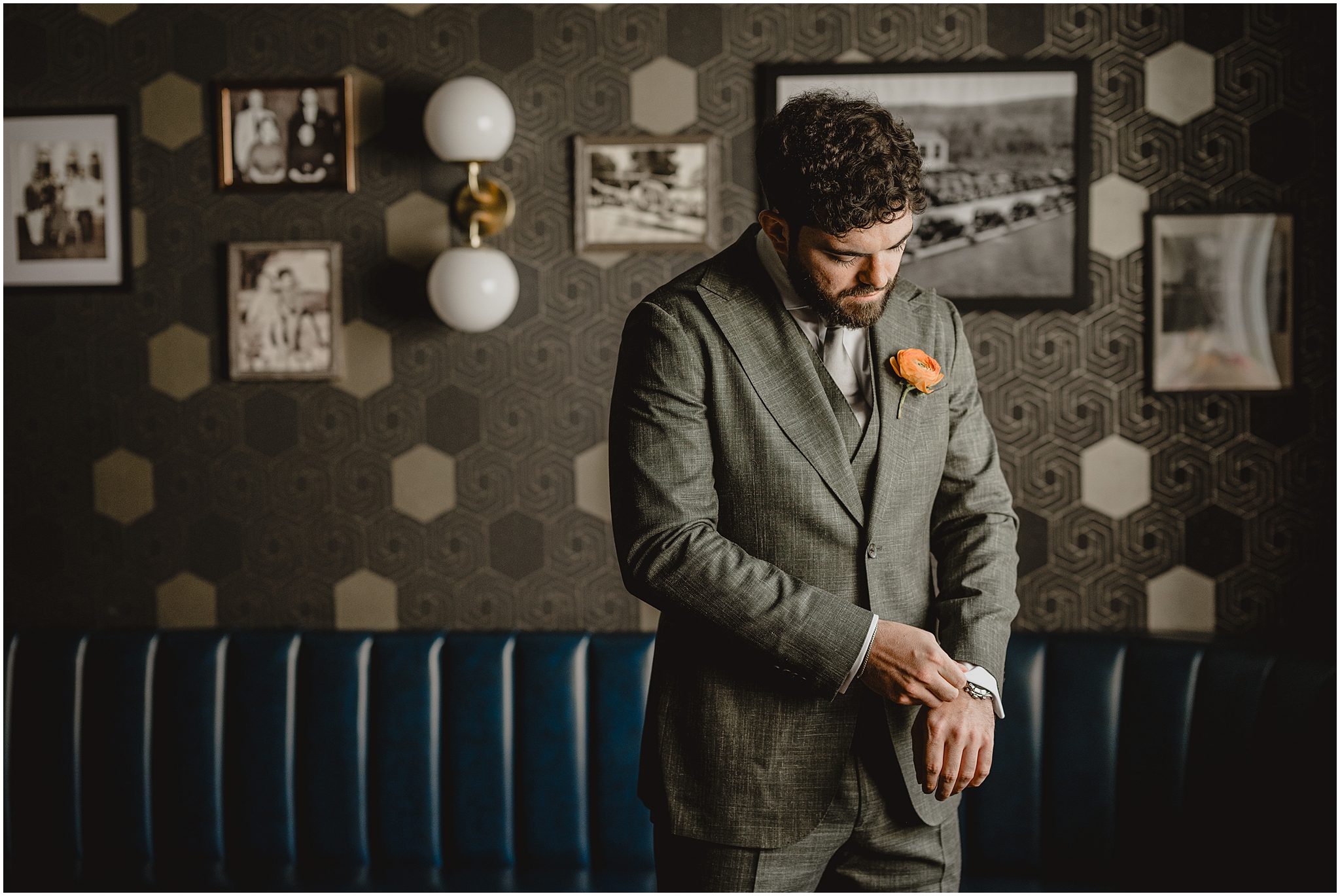 groom in grey suit with coral rose boutonnière while preparing at the Perona Farms Refinery