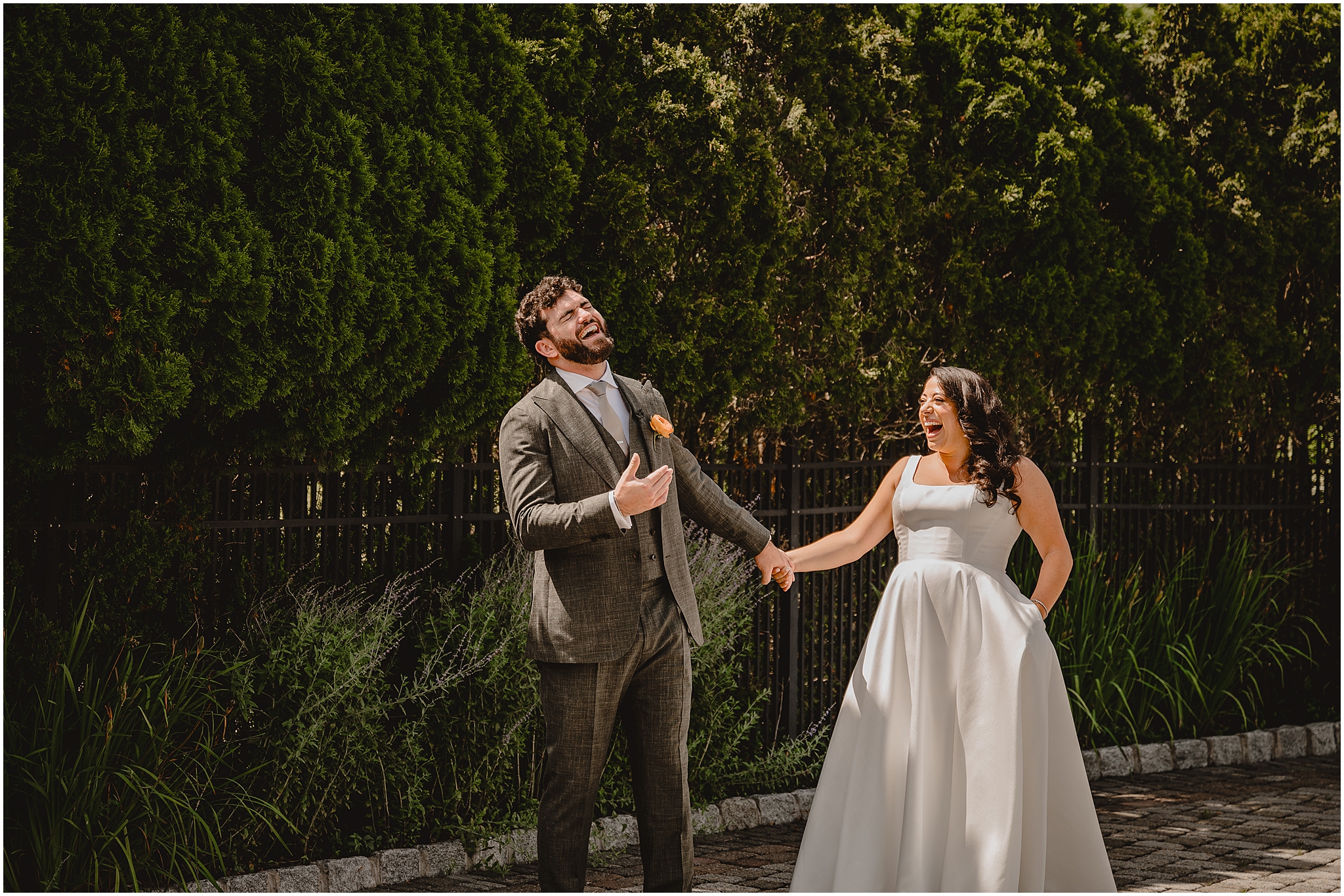 newlyweds hold hands laughing together during first look at the Perona Farms Refinery