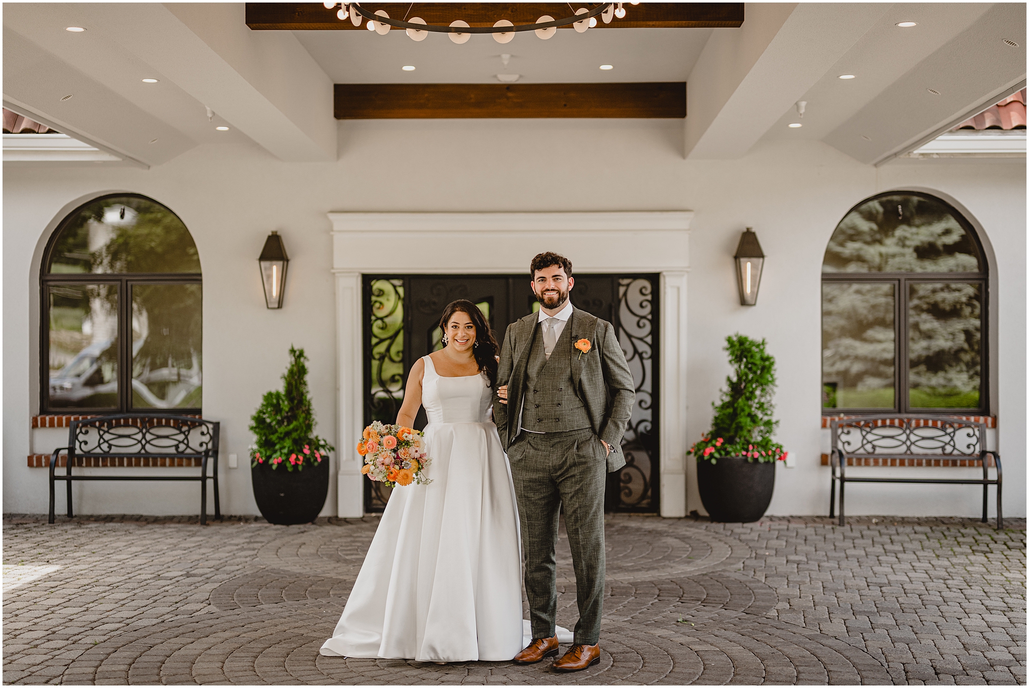 bride and groom stand together outside the Perona Farms Refinery under awning