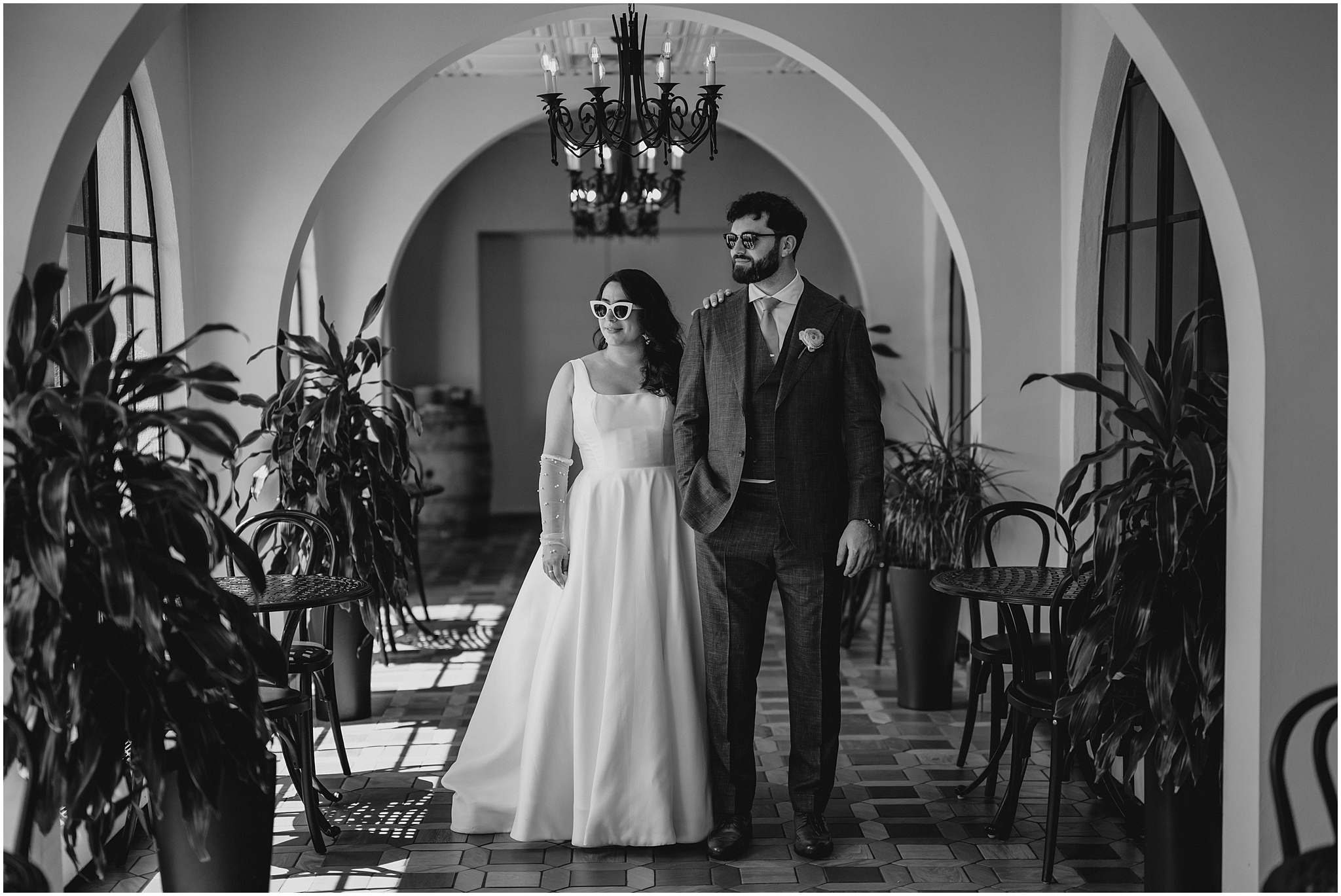 bride lays hand on groom's shoulder looking to the left inside the hallway at the Perona Farms Refinery