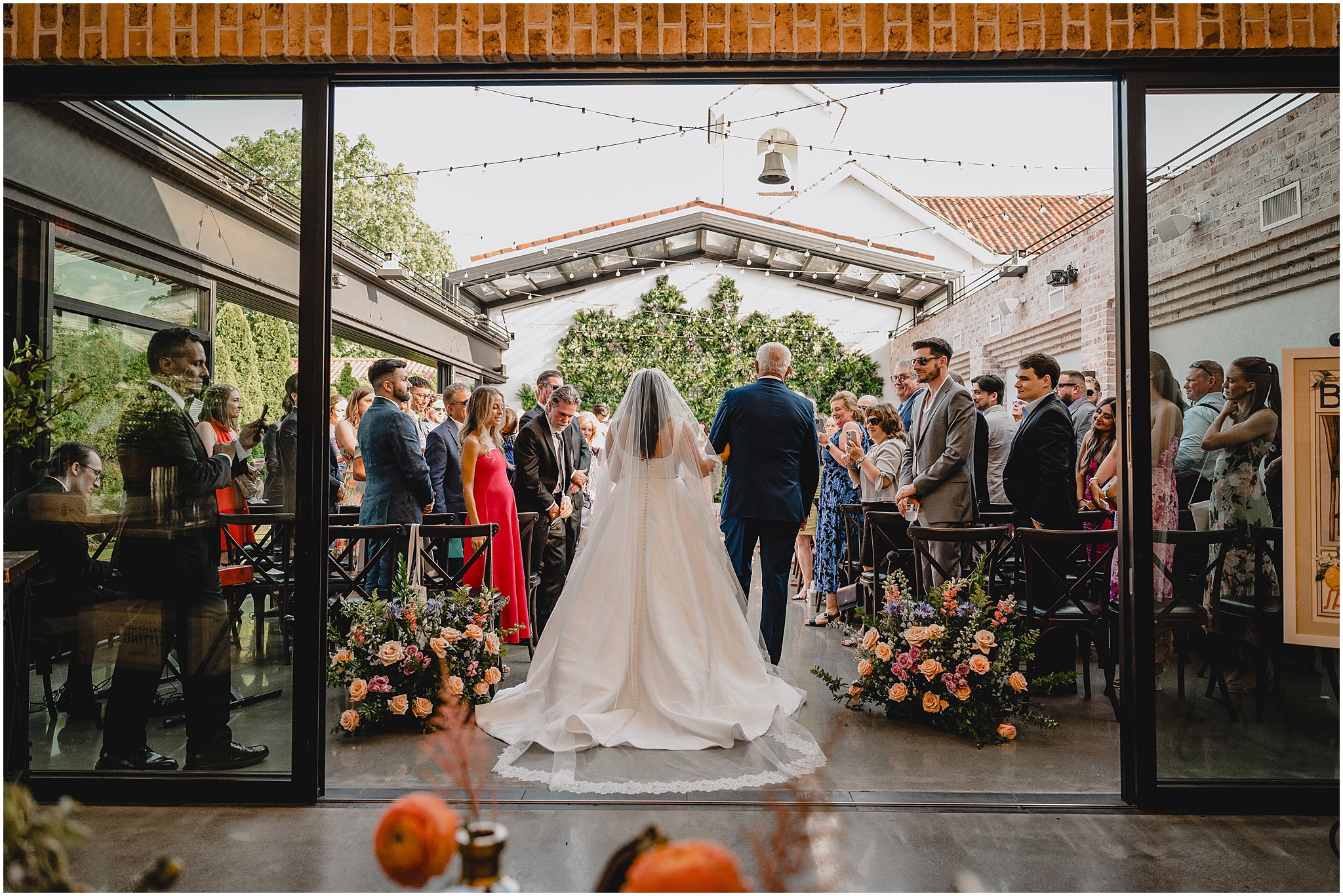 father walks bride down aisle for ceremony in atrium at the Perona Farms Refinery