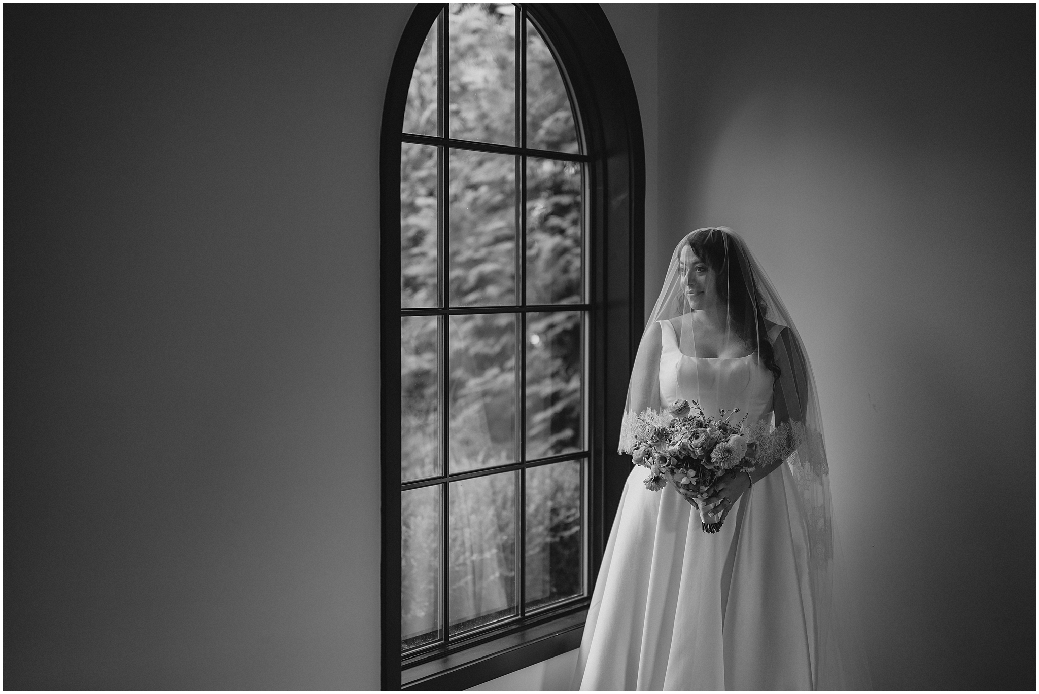 bride stands by window with veil over her face inside the Perona Farms Refinery