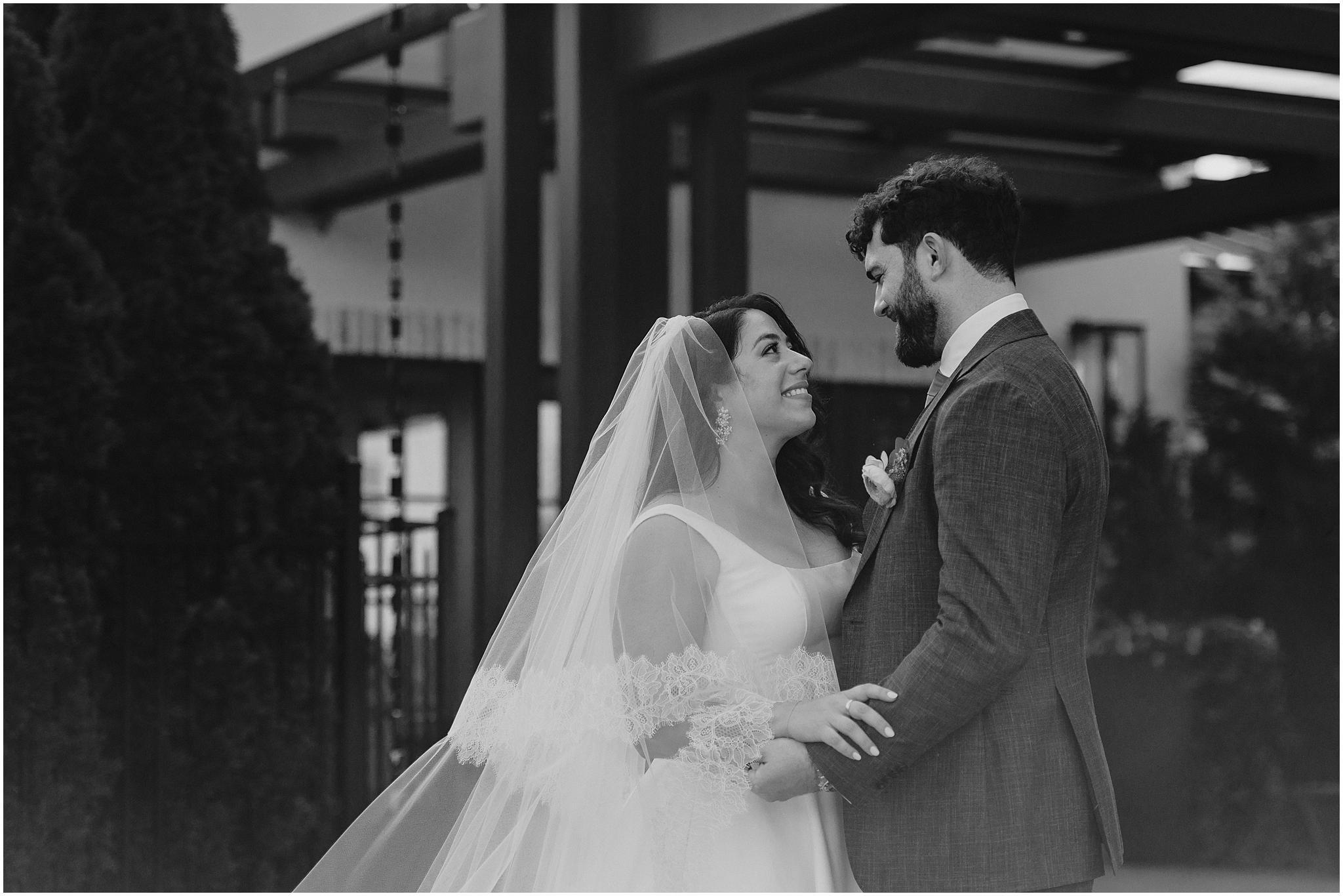 bride and groom look at each other hugging outside the Perona Farms Refinery