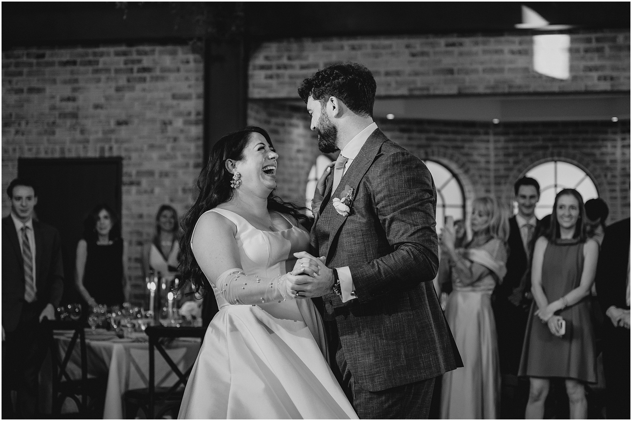 newlyweds grin and dance together during first dance at NJ wedding reception 
