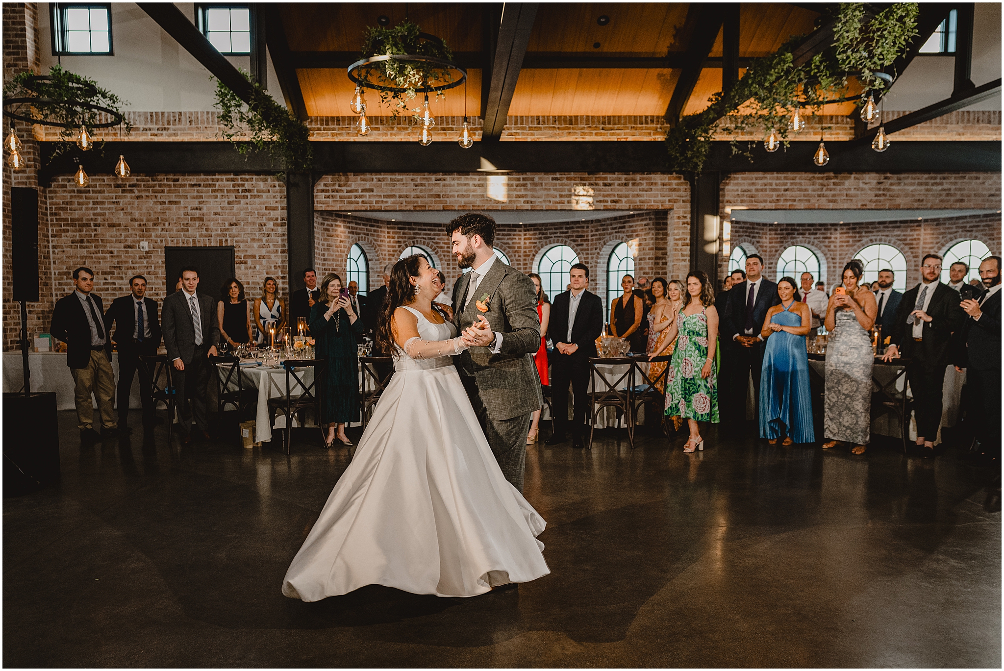 bride and groom grin on dance floor at the Perona Farms Refinery