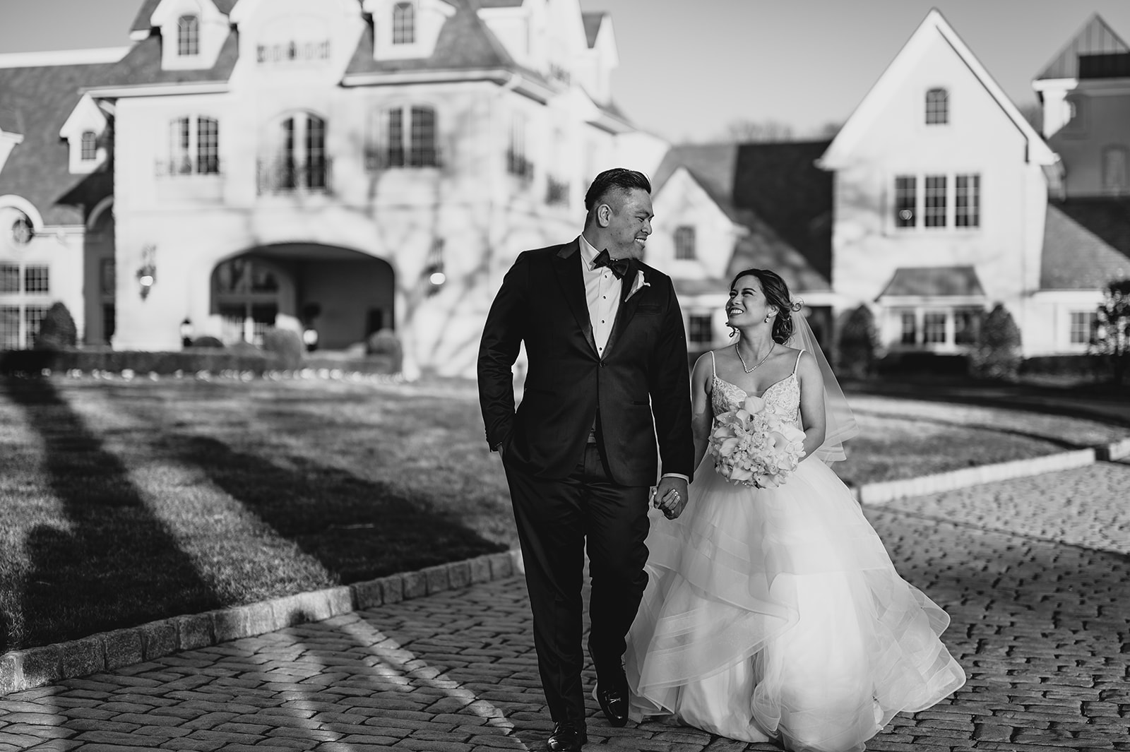 bride and groom smile up at each other outside Park Chateau Estate