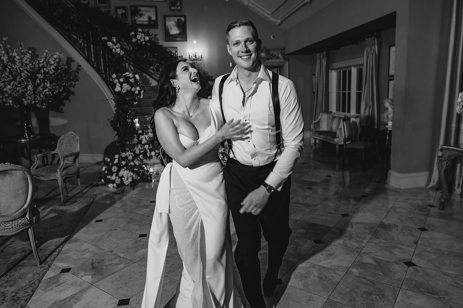 newlyweds laugh walking across lobby in Park Chateau 
