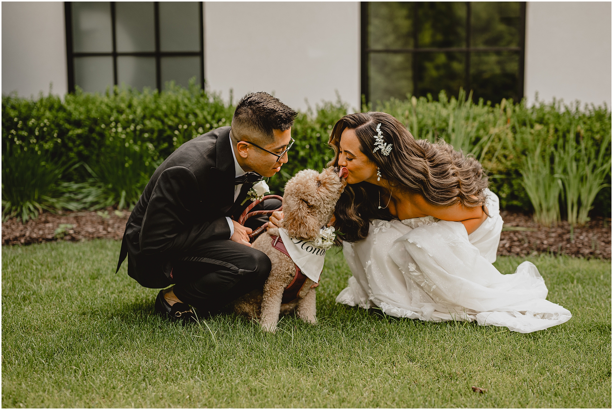 bride and groom kneel down to kiss golden doodle dog during NJ wedding day