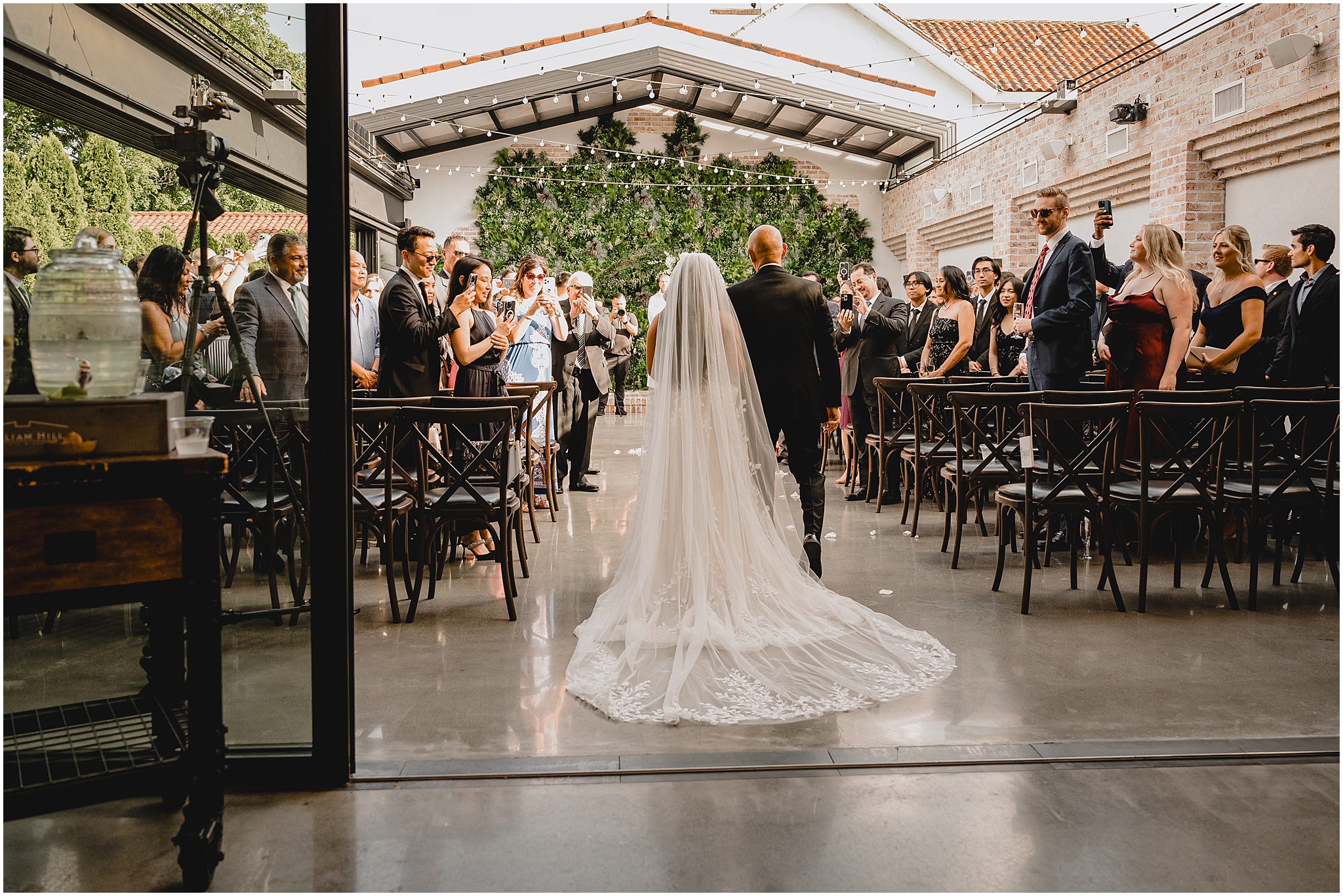 bride walks down aisle with father in the outdoor space at the Refinery at Perona Farms