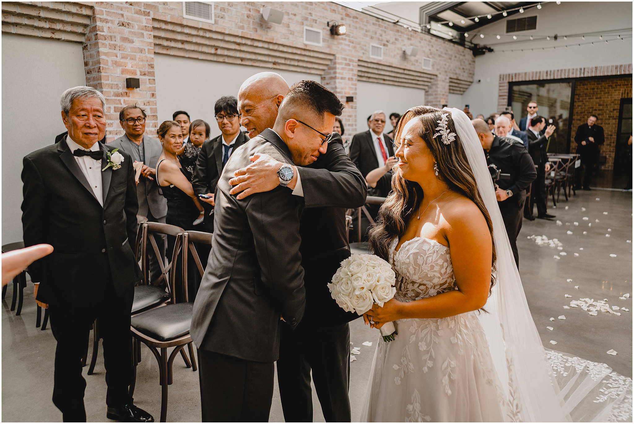 bride's dad hugs groom during wedding ceremony at the Refinery at Perona Farms