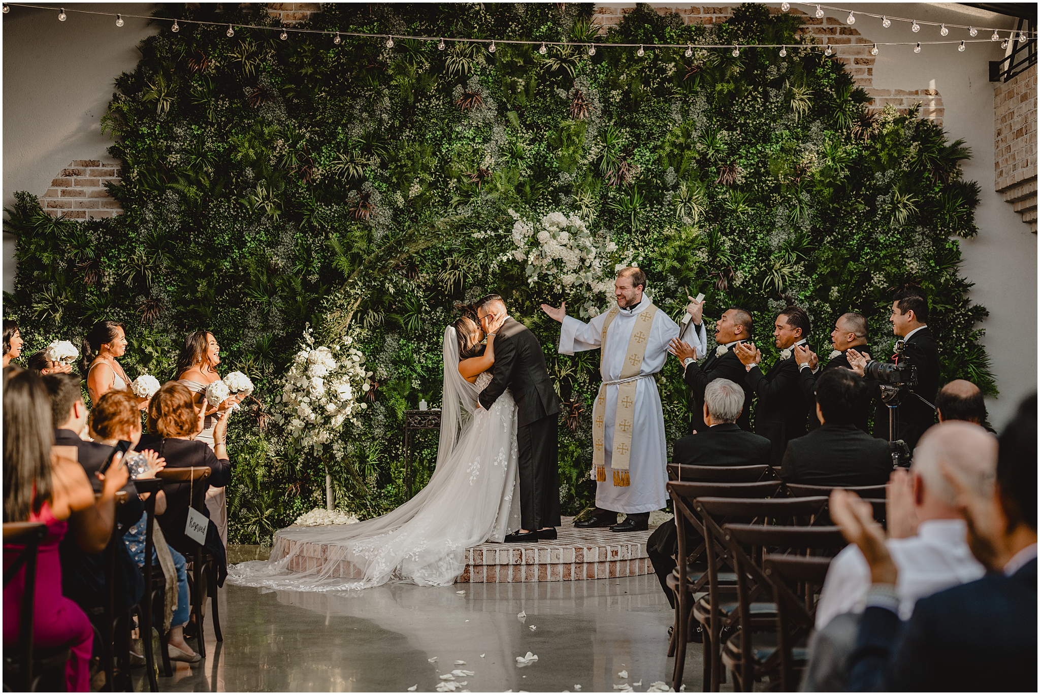 groom kisses bride dipping her gently after ceremony in courtyard at the Refinery at Perona Farms