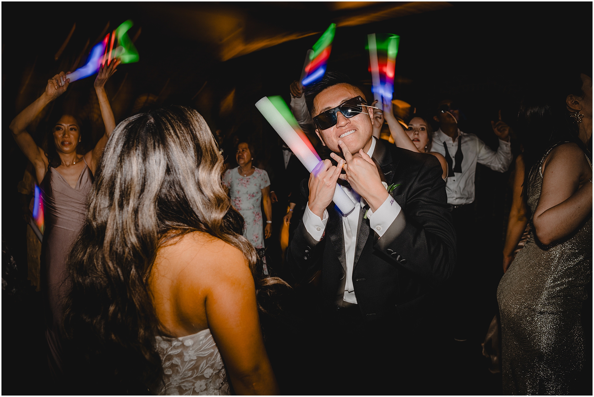 bride and groom dance with guests and glow sticks during Andover NJ wedding reception