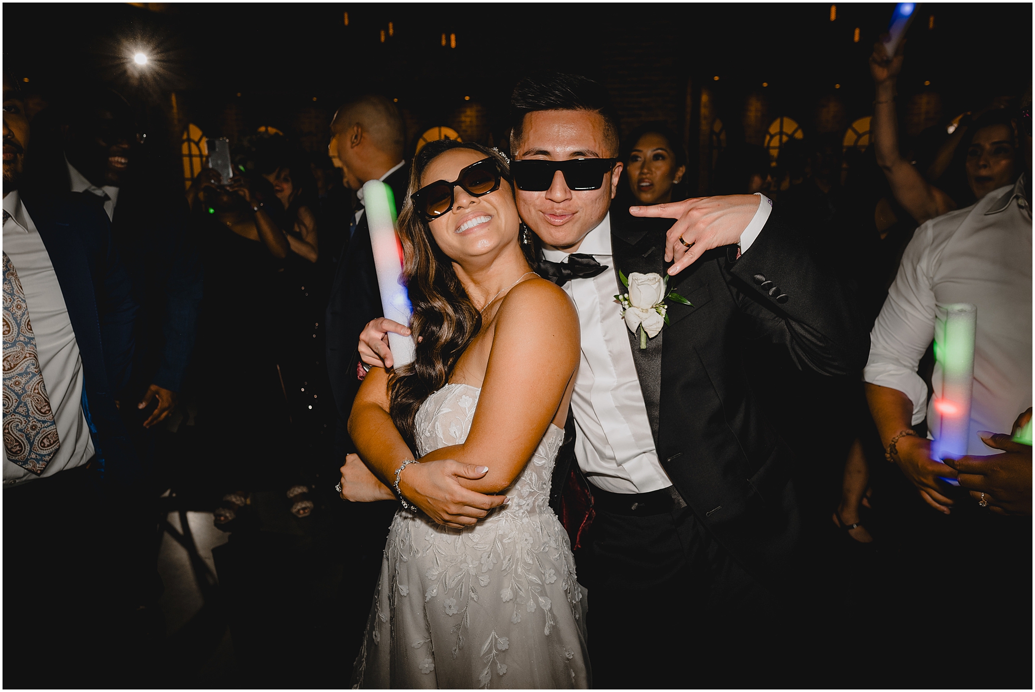 bride and groom laugh standing on dance floor with glow sticks and sunglasses during Andover NJ wedding reception