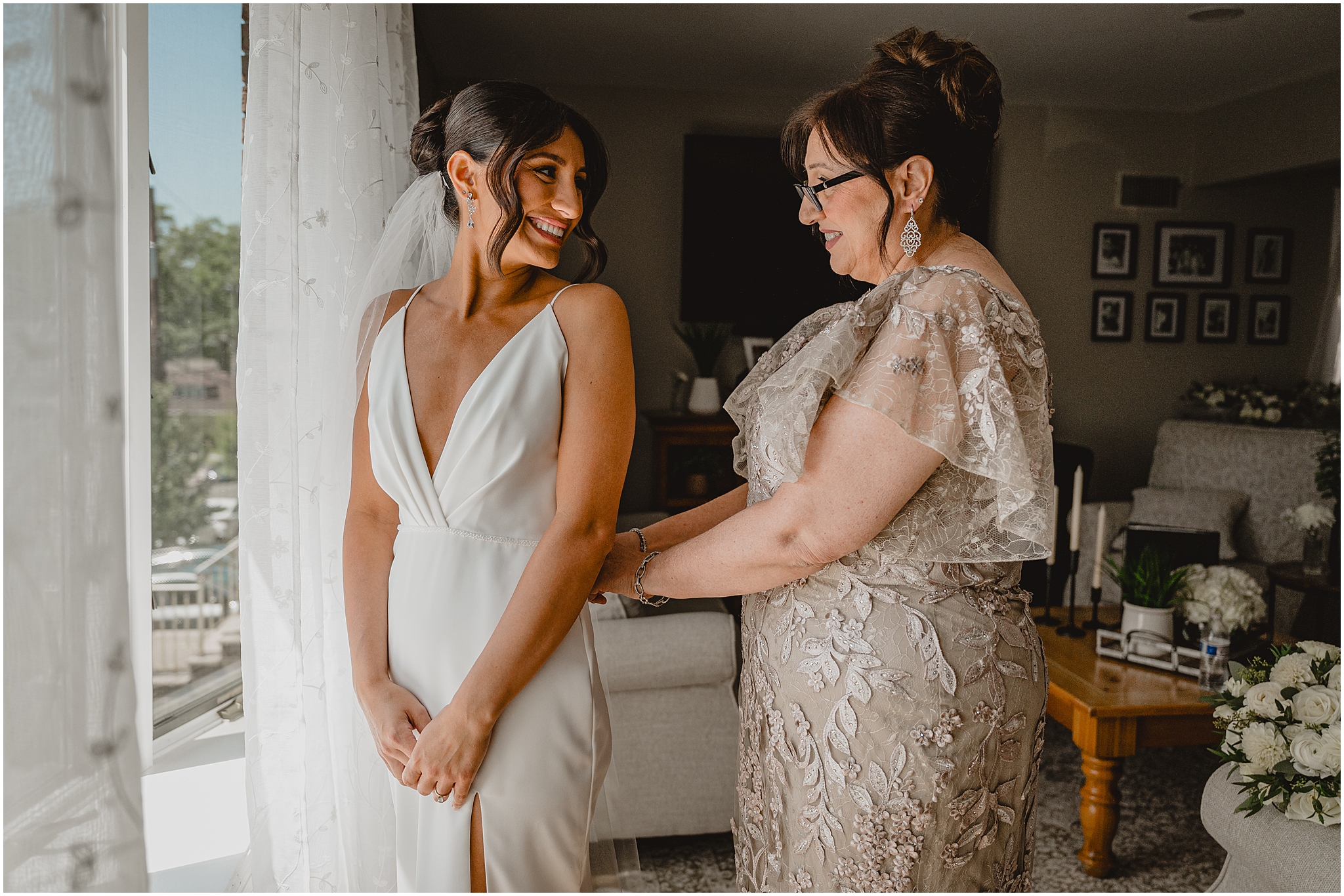 mother helps bride into wedding dress in living room of Jersey City home