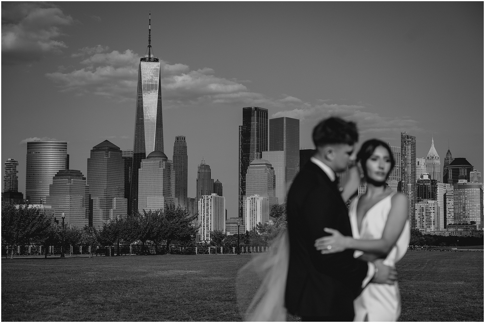bride and groom blurred in front of the Freedom Tower and Manhattan skyline