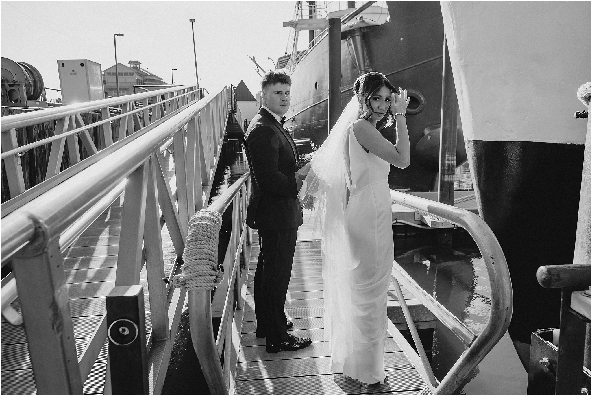 bride and groom stand on dock near ship in New Jersey