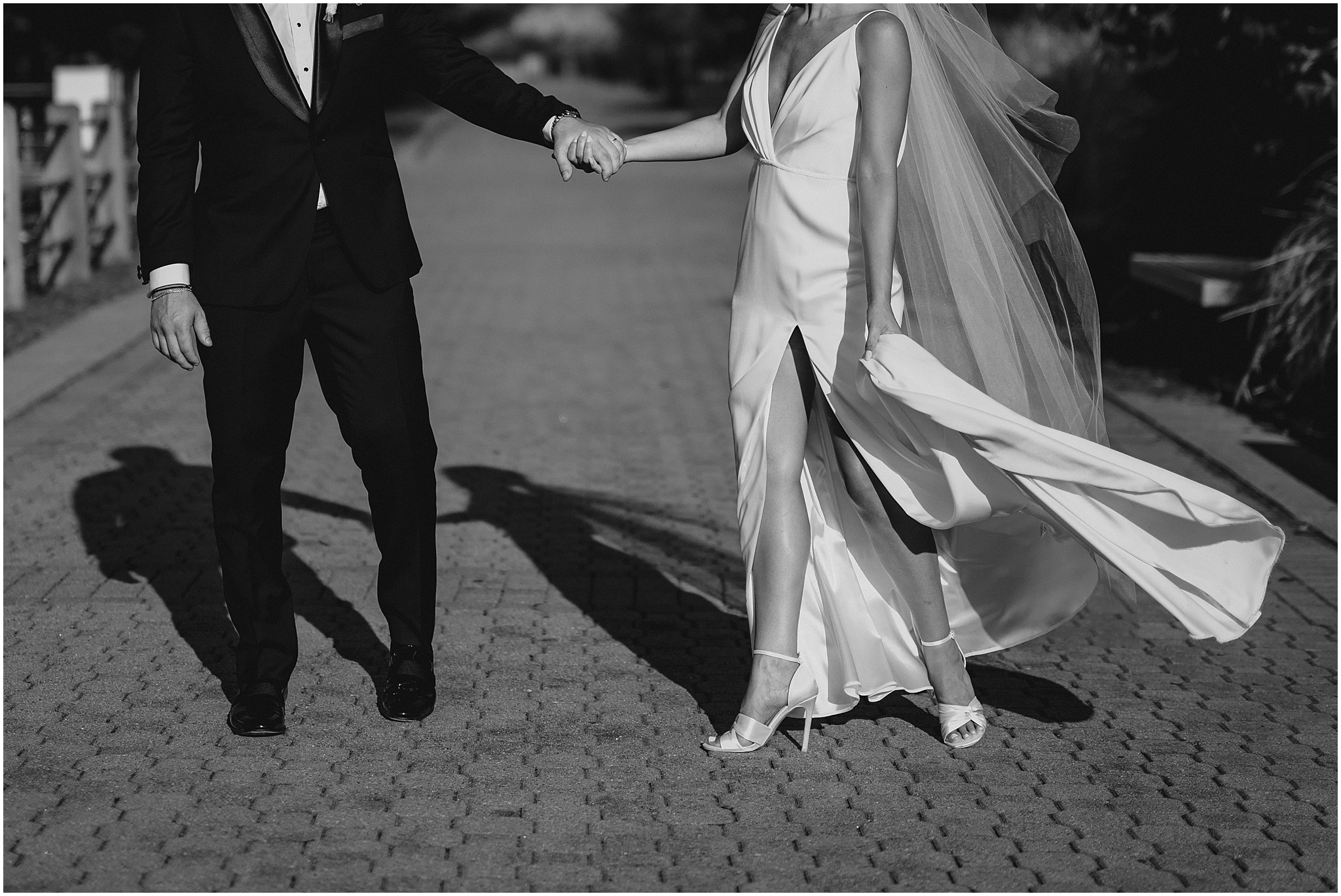 bride holds wedding dress skirt showing off white stilettos 