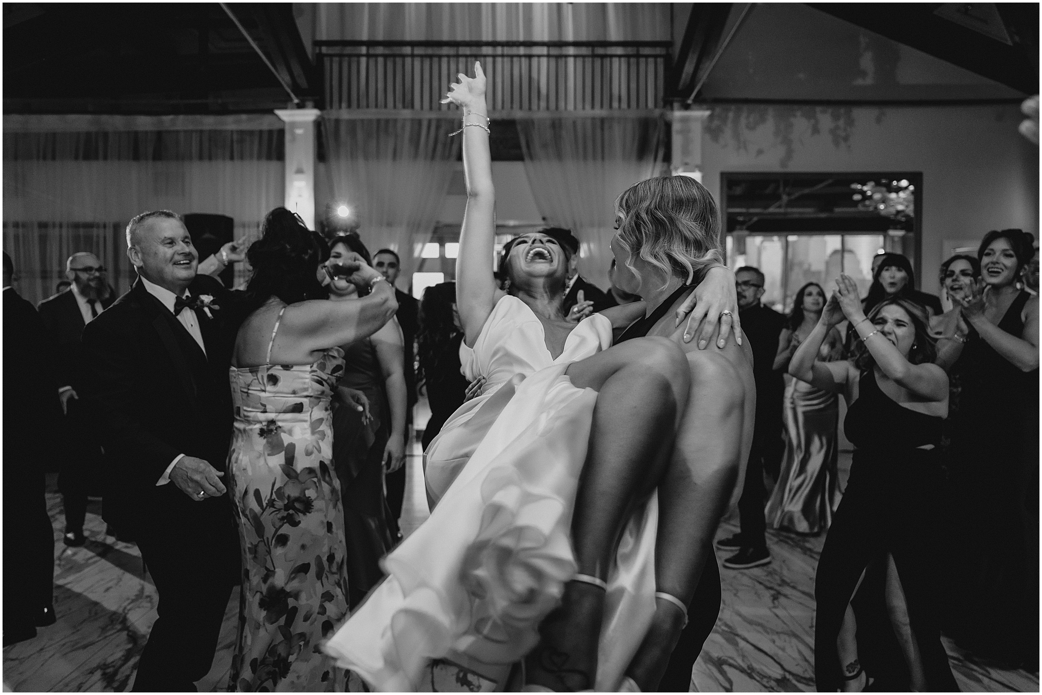 guest lifts up bride during Liberty House wedding reception