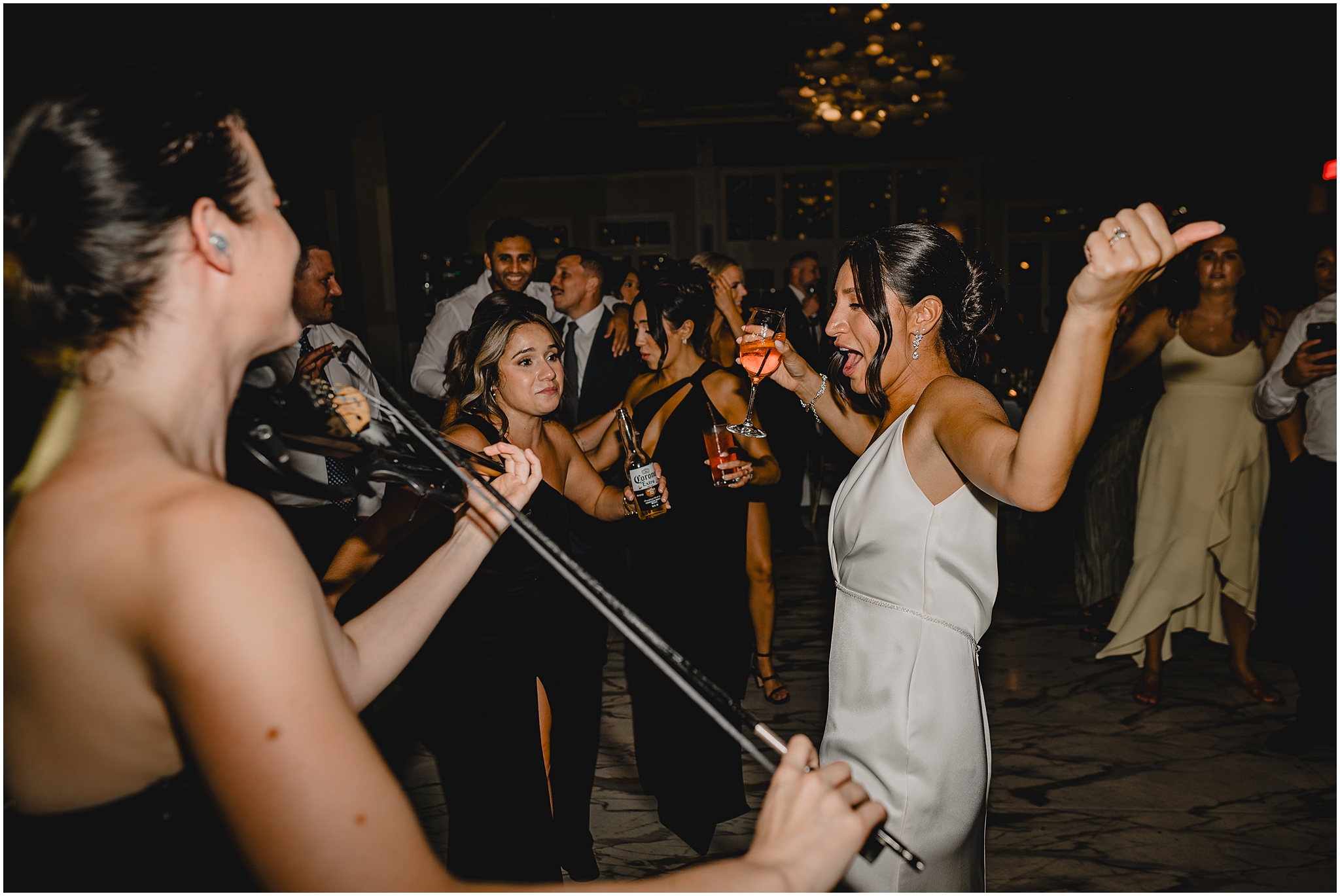 bride dances with guests and live violin player during Liberty House wedding reception