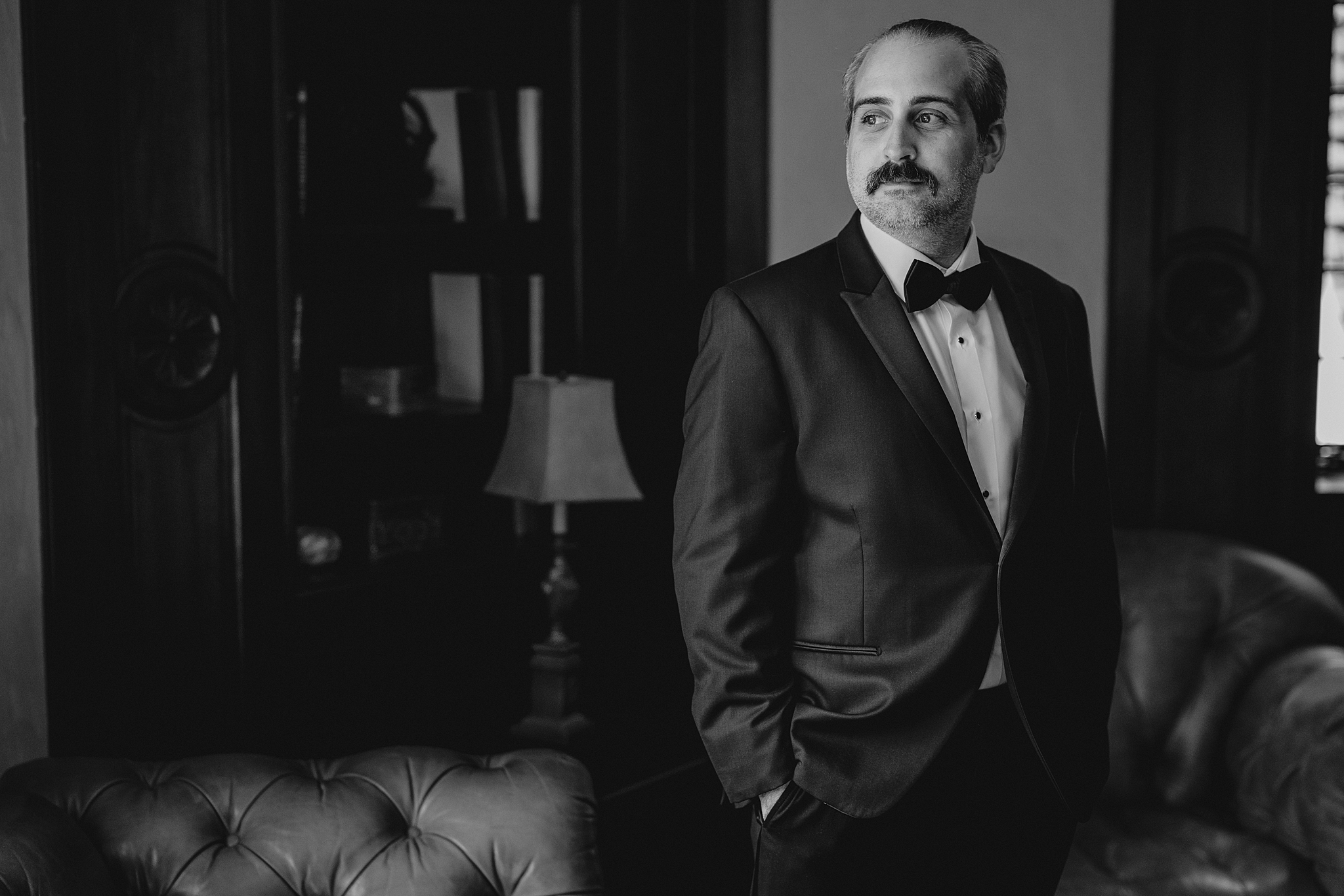 groom stands with his hands in pockets of suit before NJ wedding day