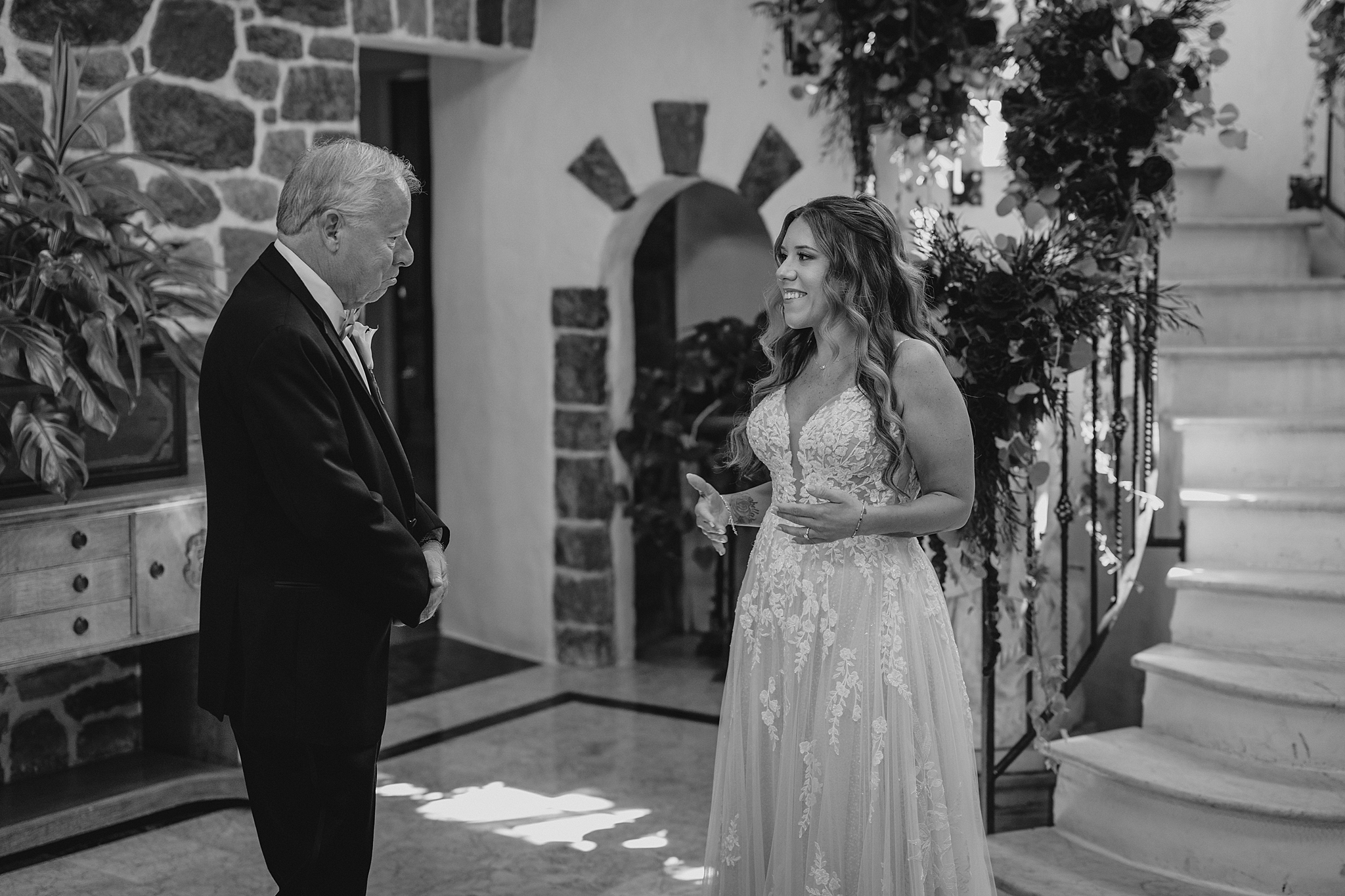 bride talks with dad during first look at the bottom of the staircase in New Jersey wedding venue