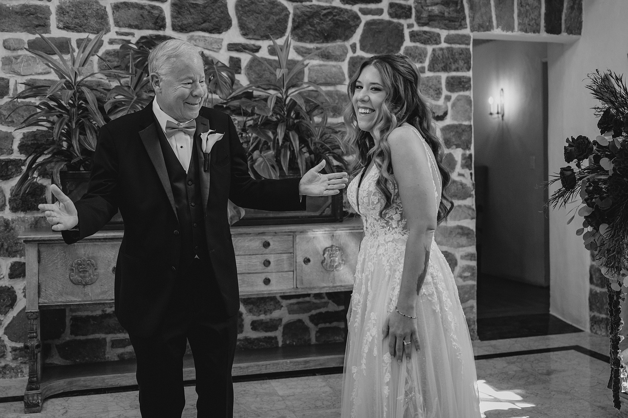 bride laughs with dad during first look in lobby at Pleasantdale Chateau