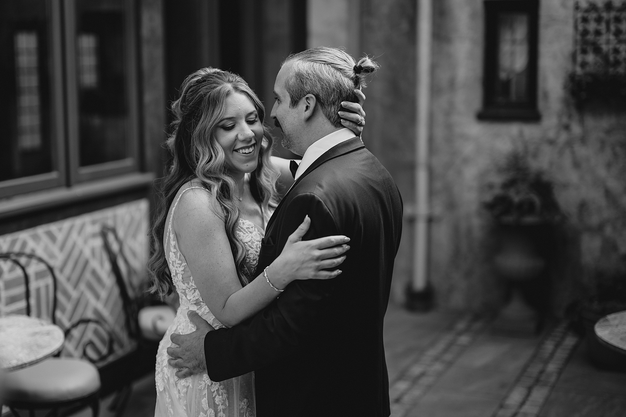 newlyweds hug on patio at Pleasantdale Chateau