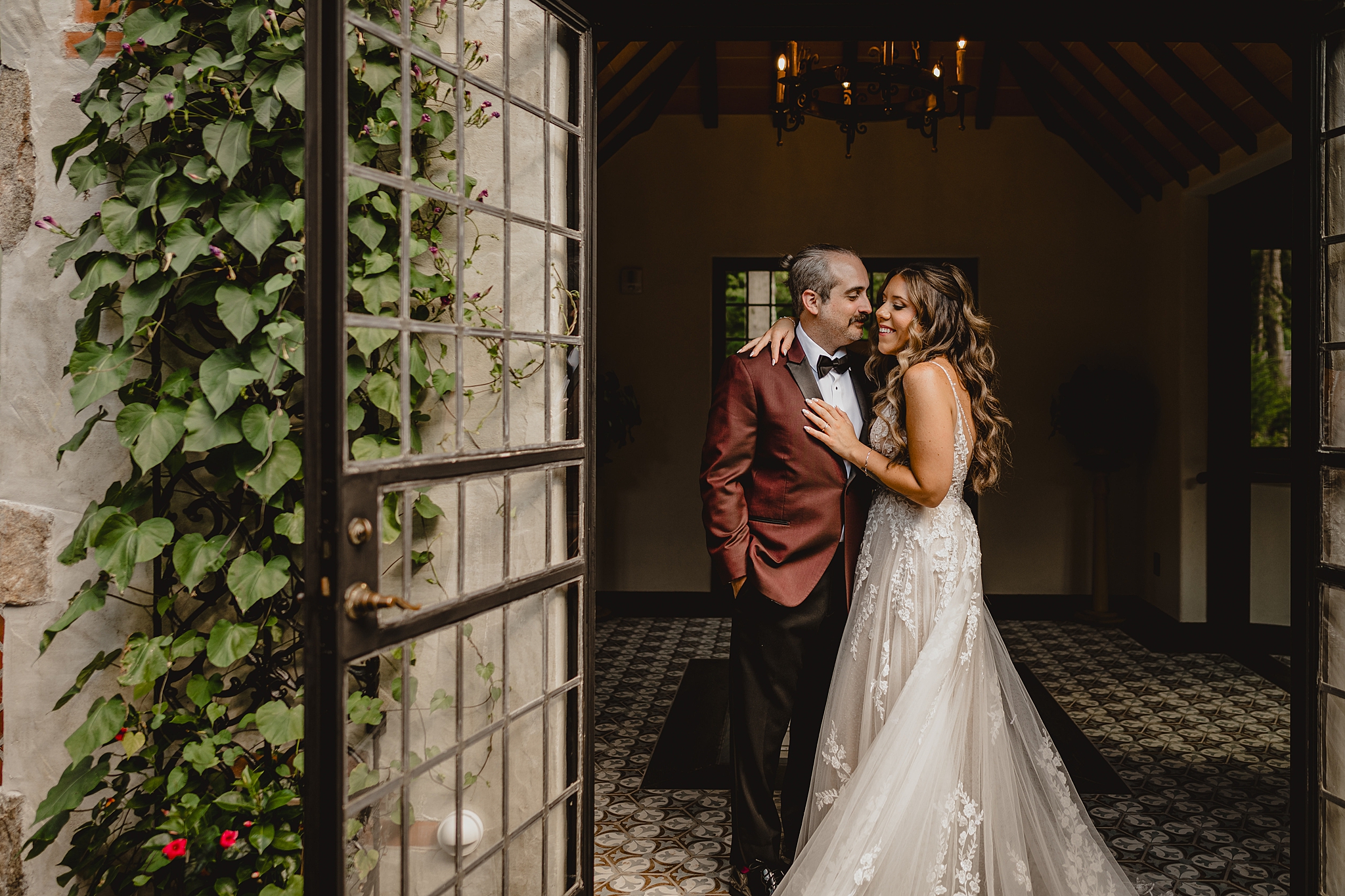 bride hugs groom while they smile together in open doorway at Pleasantdale Chateau