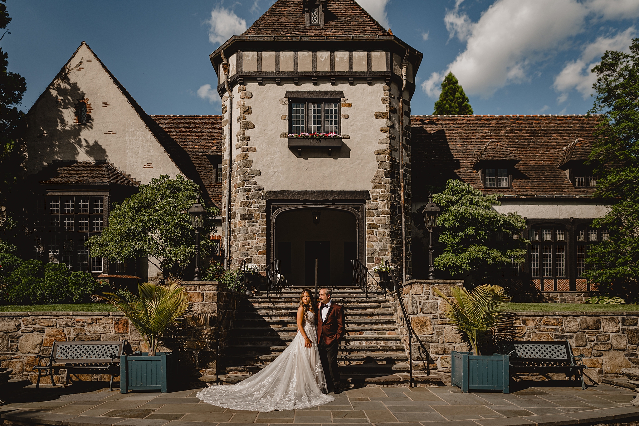 bride and groom stand outside Pleasantdale Chateau on stone patio in West Orange NJ