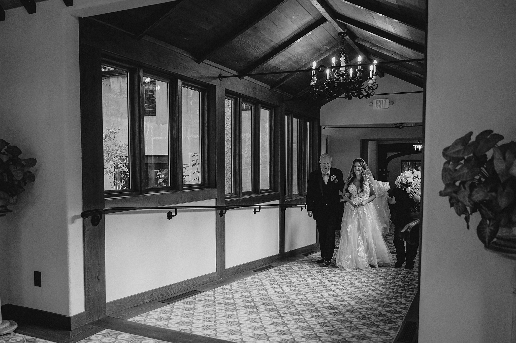 bride walks down hallway with father inside Pleasantdale Chateau