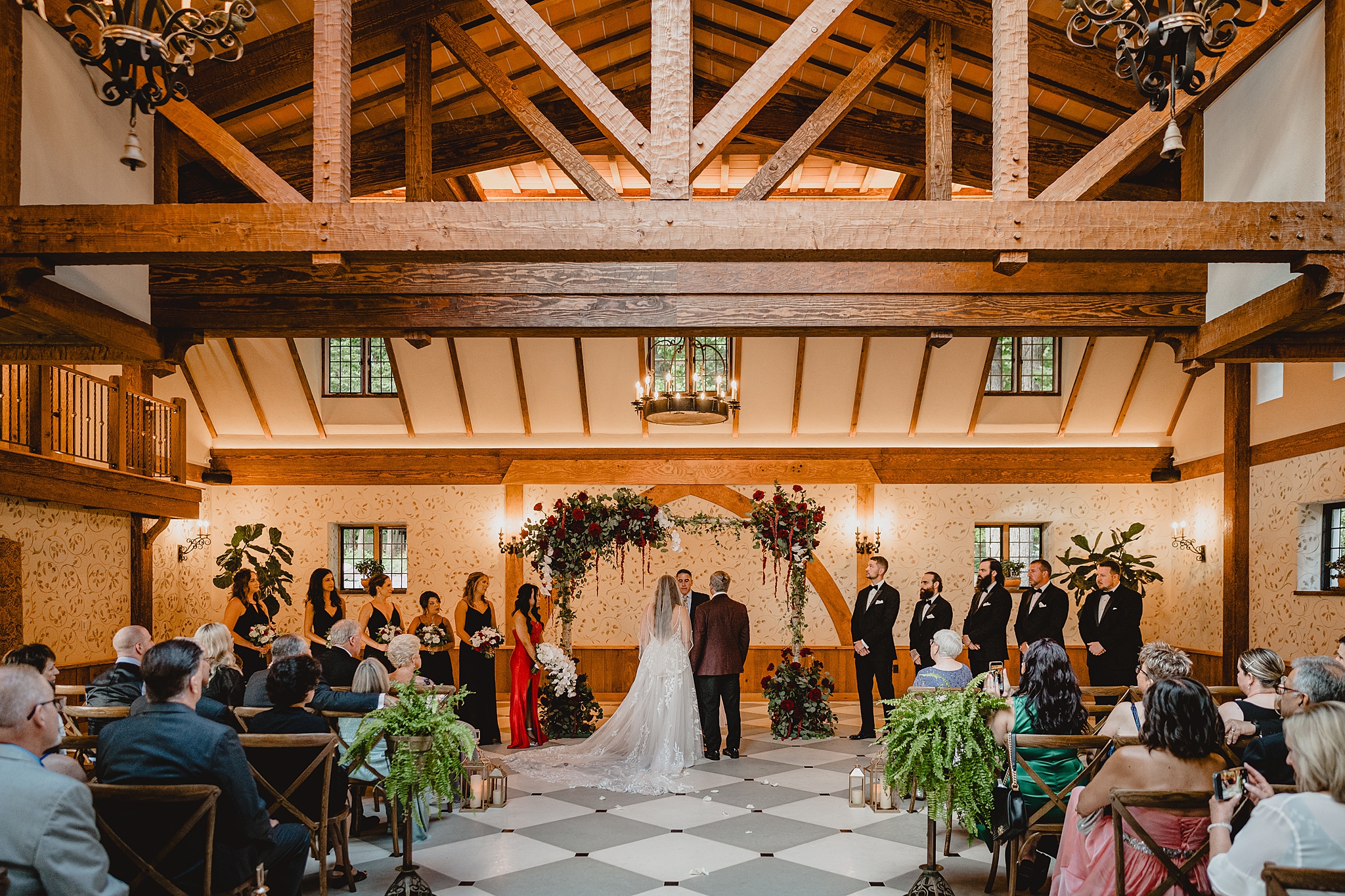 newlyweds stand by alter under wooden beams inside Pleasantdale Chateau