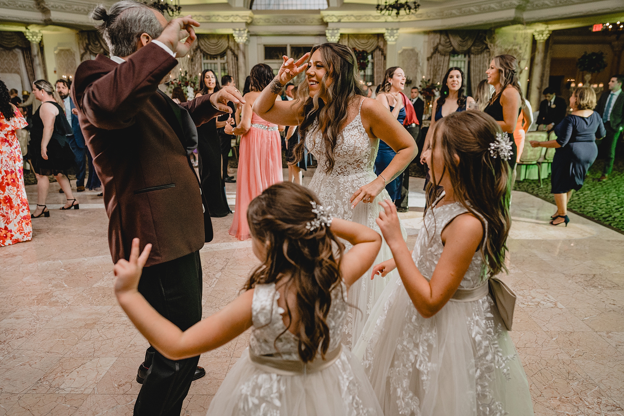 bride and groom dance with flower girls in the ballroom at Pleasantdale Chateau